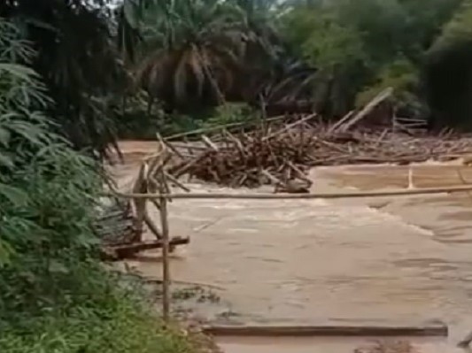 Suasana jembatan kayu ambruk dan dihanyutkan arus luapan Sungai Pengabuan di Kecamatan Renah Mendaluh, Kabupaten Tanjungjabung Barat, Jambi.