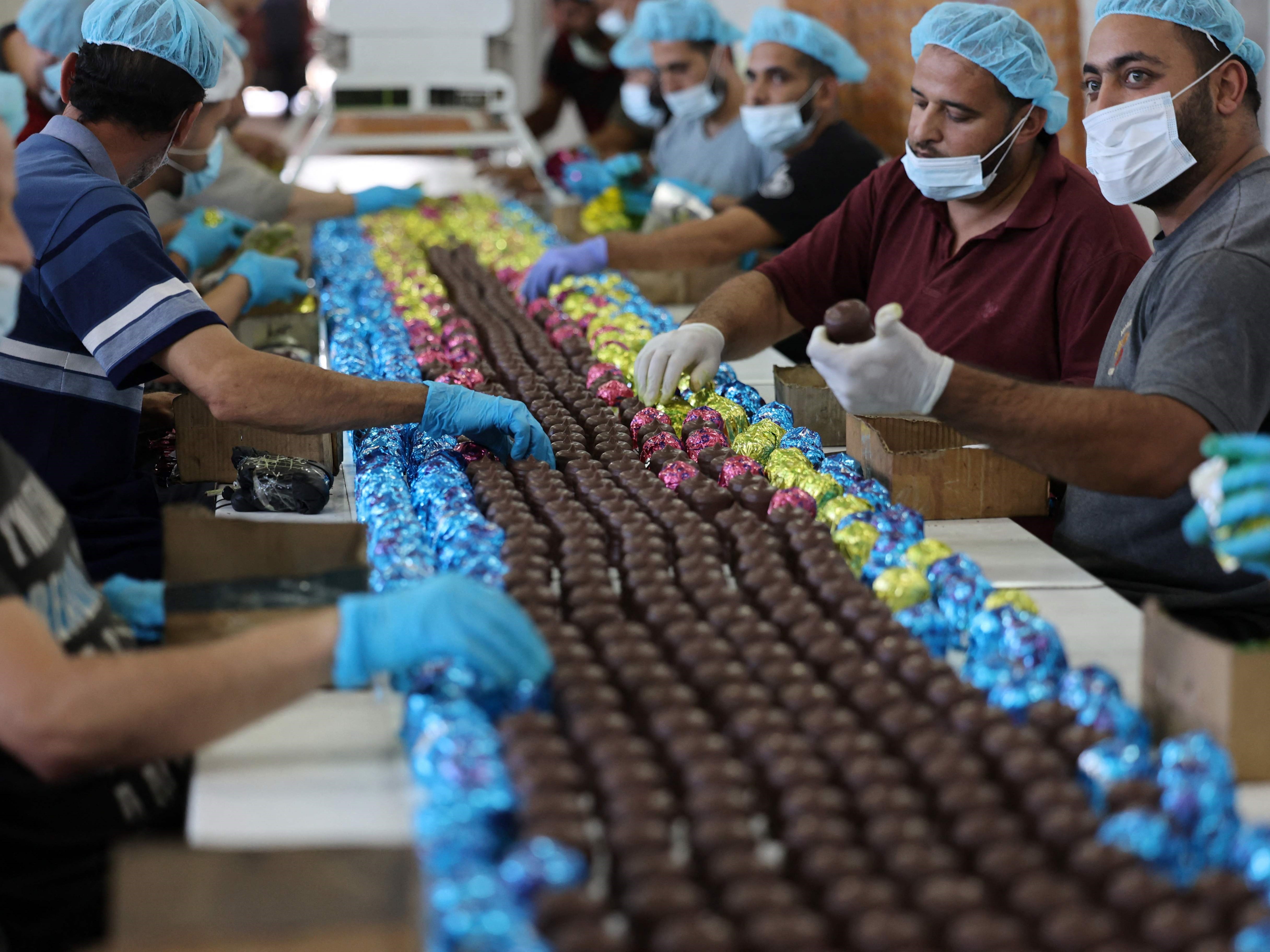 Pekerja Palestina membuat permen krim berlapis cokelat di pabrik Al-Arees di Kota Gaza pada 7 Oktober 2021.