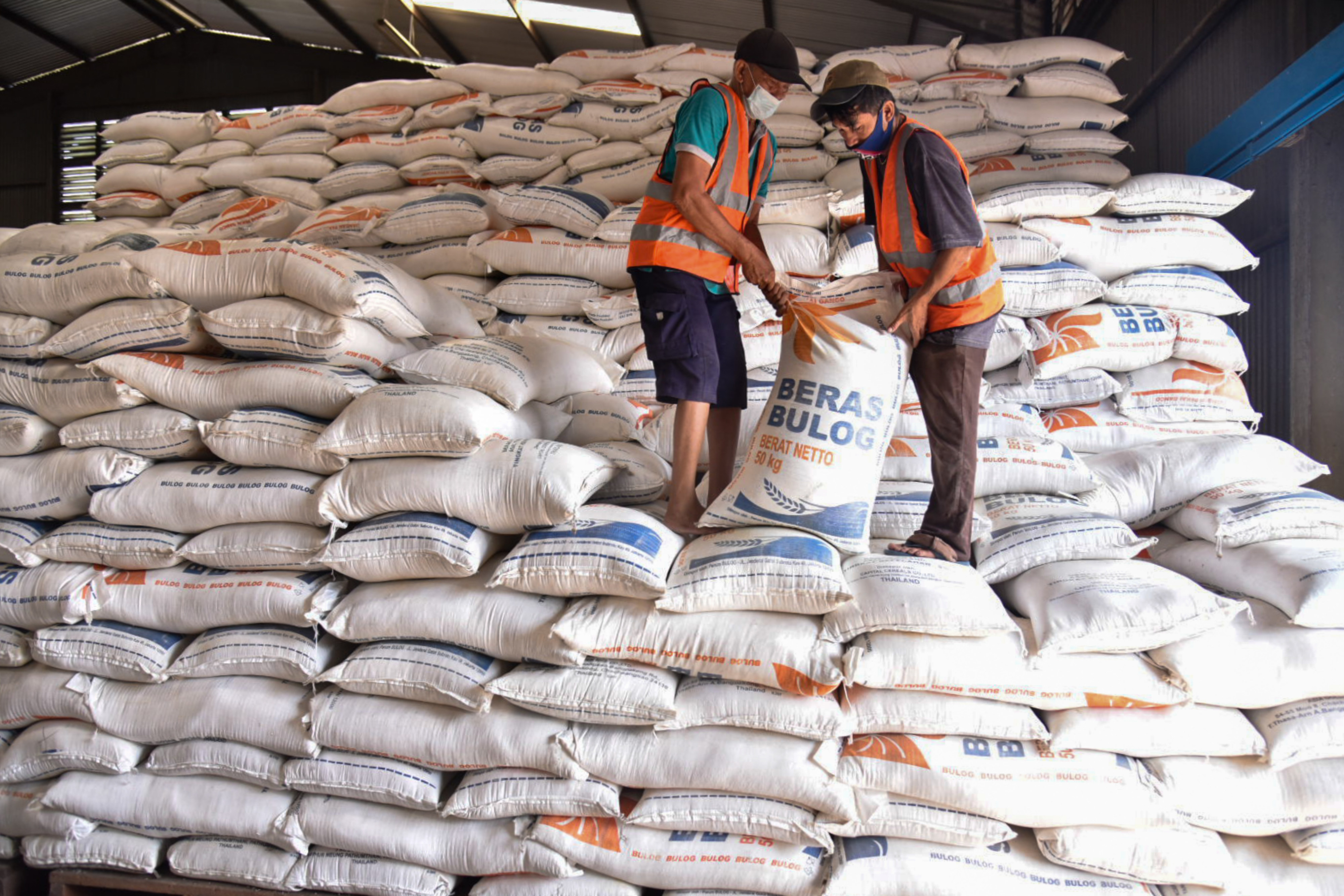 Pekerja menyusun karung berisi beras di gudang Perum Bulog Kantor Wilayah Sumatera Utara, Medan, Sumatera Utara, Jumat (10/9).