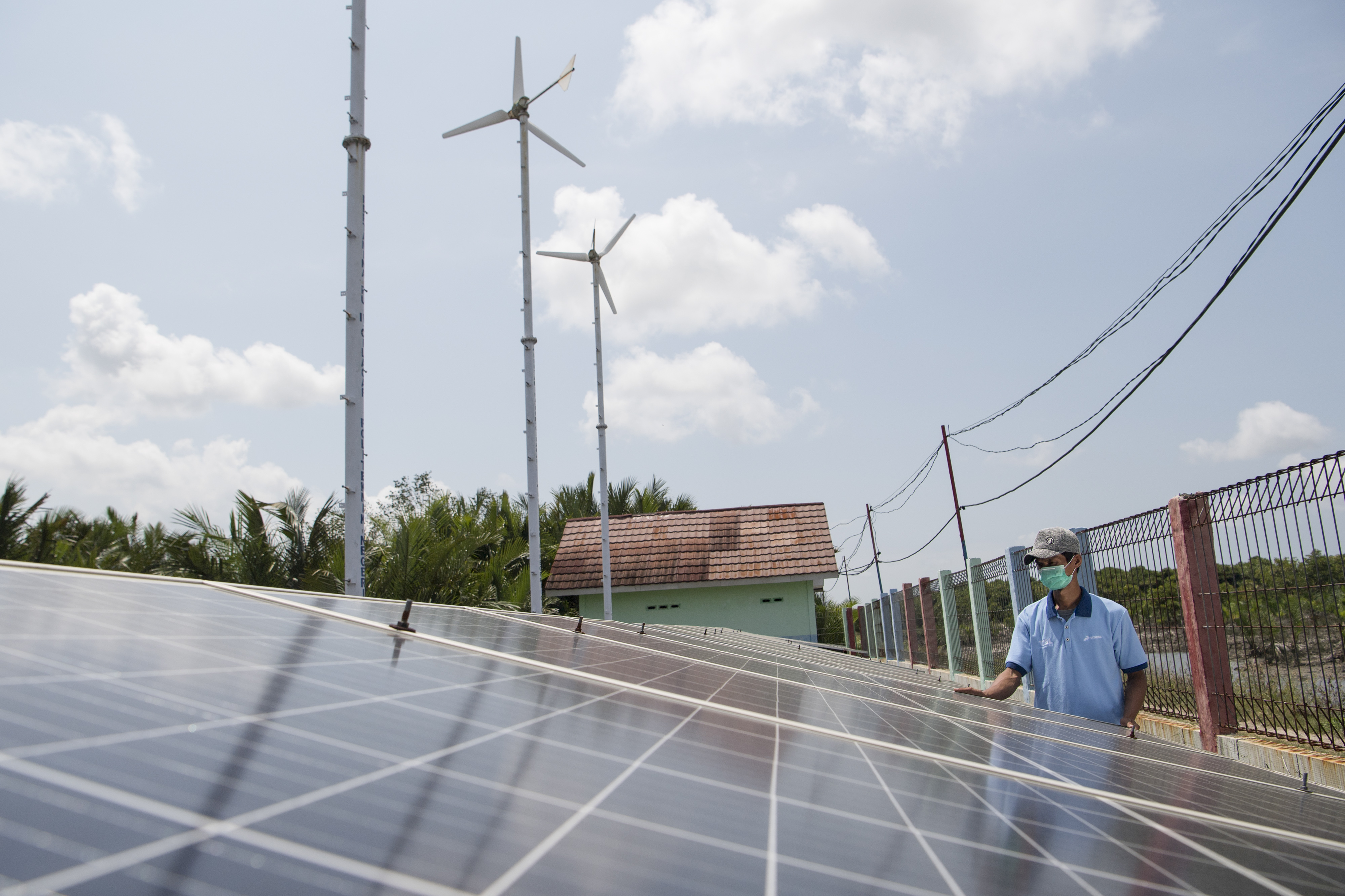 Warga memeriksa panel surya untuk Pembangkit Listrik Tenaga Hybrid di Dusun Bondan, Desa Ujung Alang, Kampung Laut, Cilacap, Jawa Tengah.