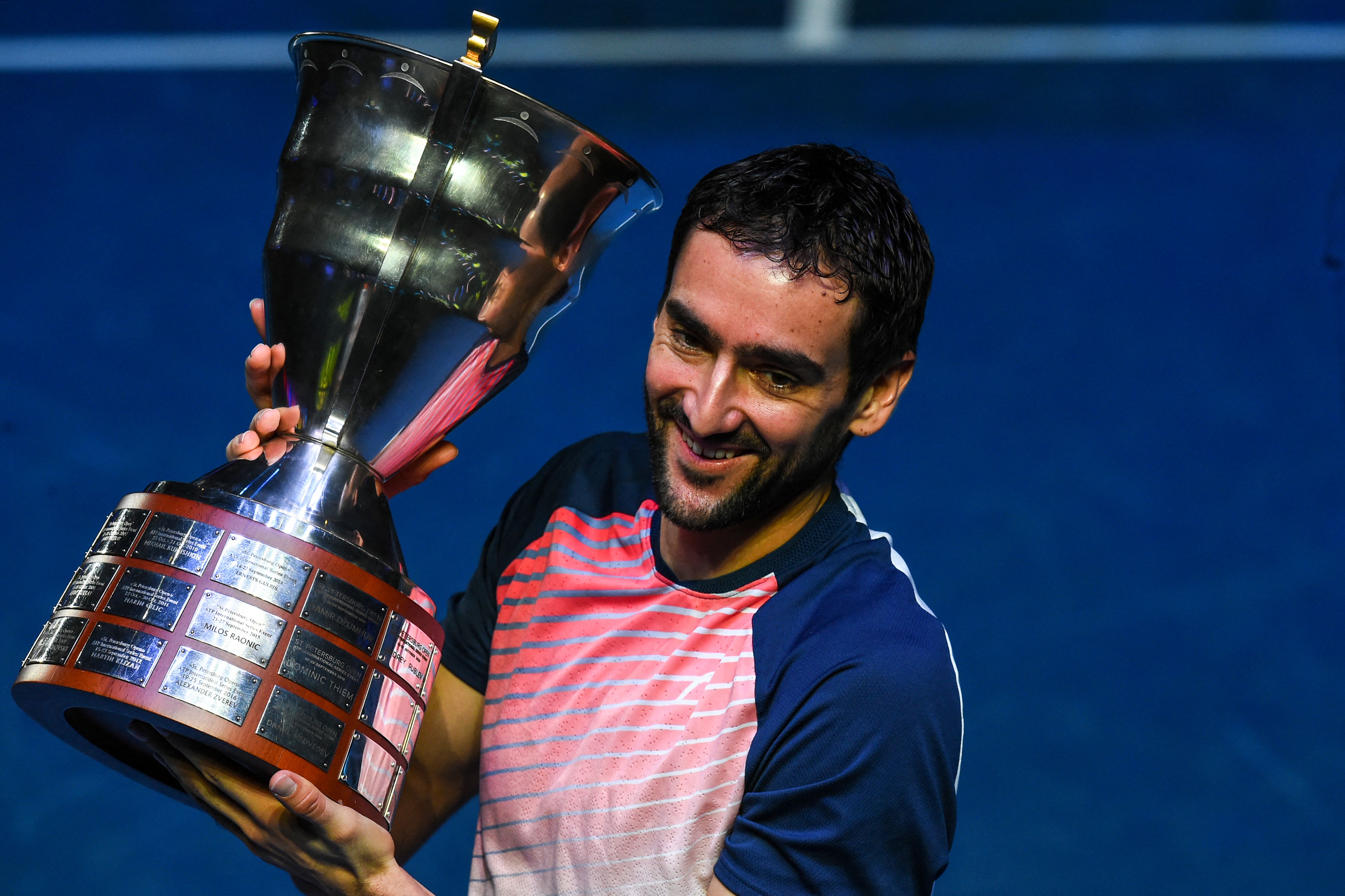 Petenis Kroasia Marin Cilic mengangkat trofi yang dimenangkannya di Saint Petersburg.