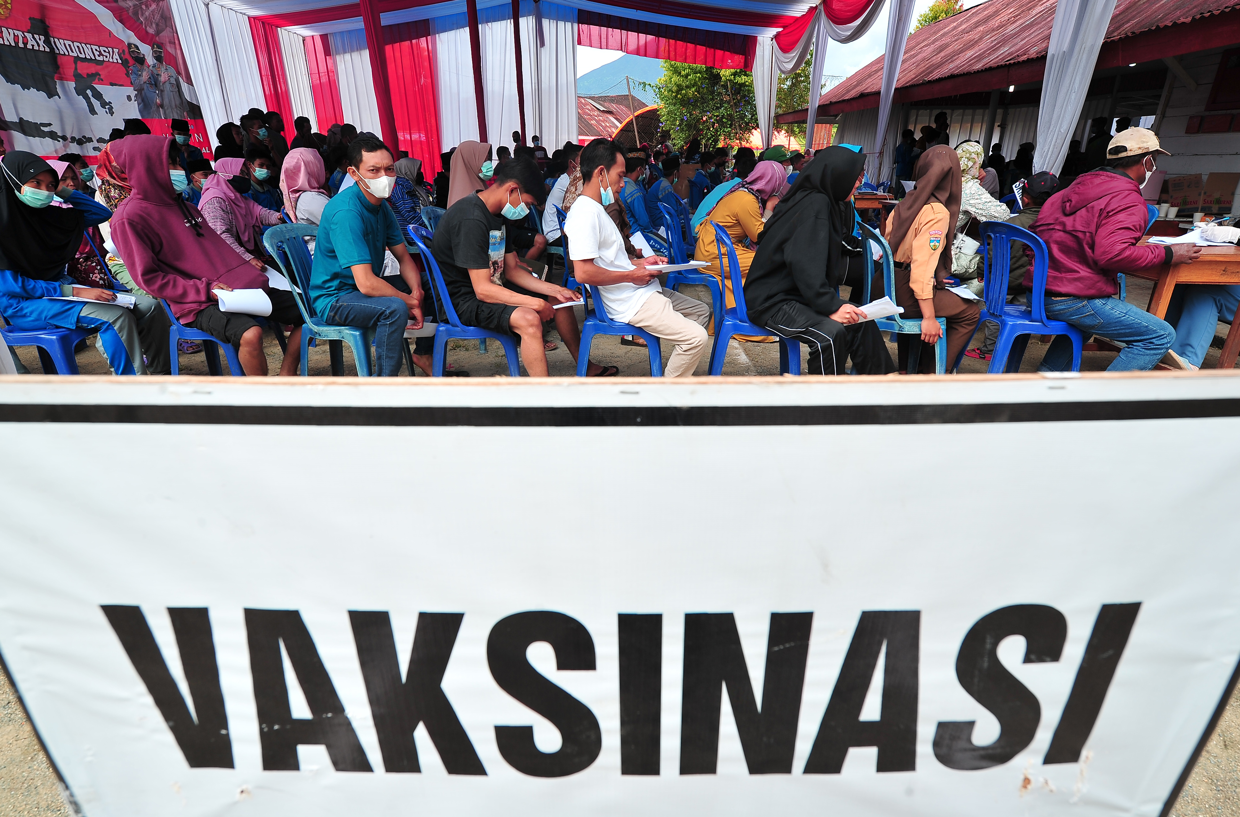 Warga antre saat vaksinasi covid-19 massal yang digelar Polres Kerinci di Bedeng Delapan, Kayu Aro Barat, Kerinci, Jambi, Sabtu (27/11/2021)