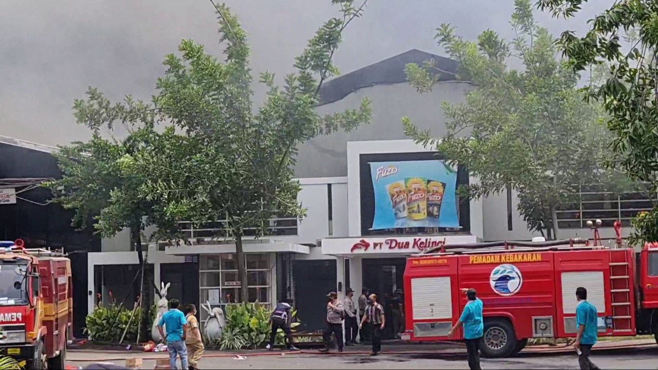 Petugas masih berusaha memadamkan kobaran api di pabrik kacang PT Dua Kelinci di Pati yang terbakar, Senin (23/11)