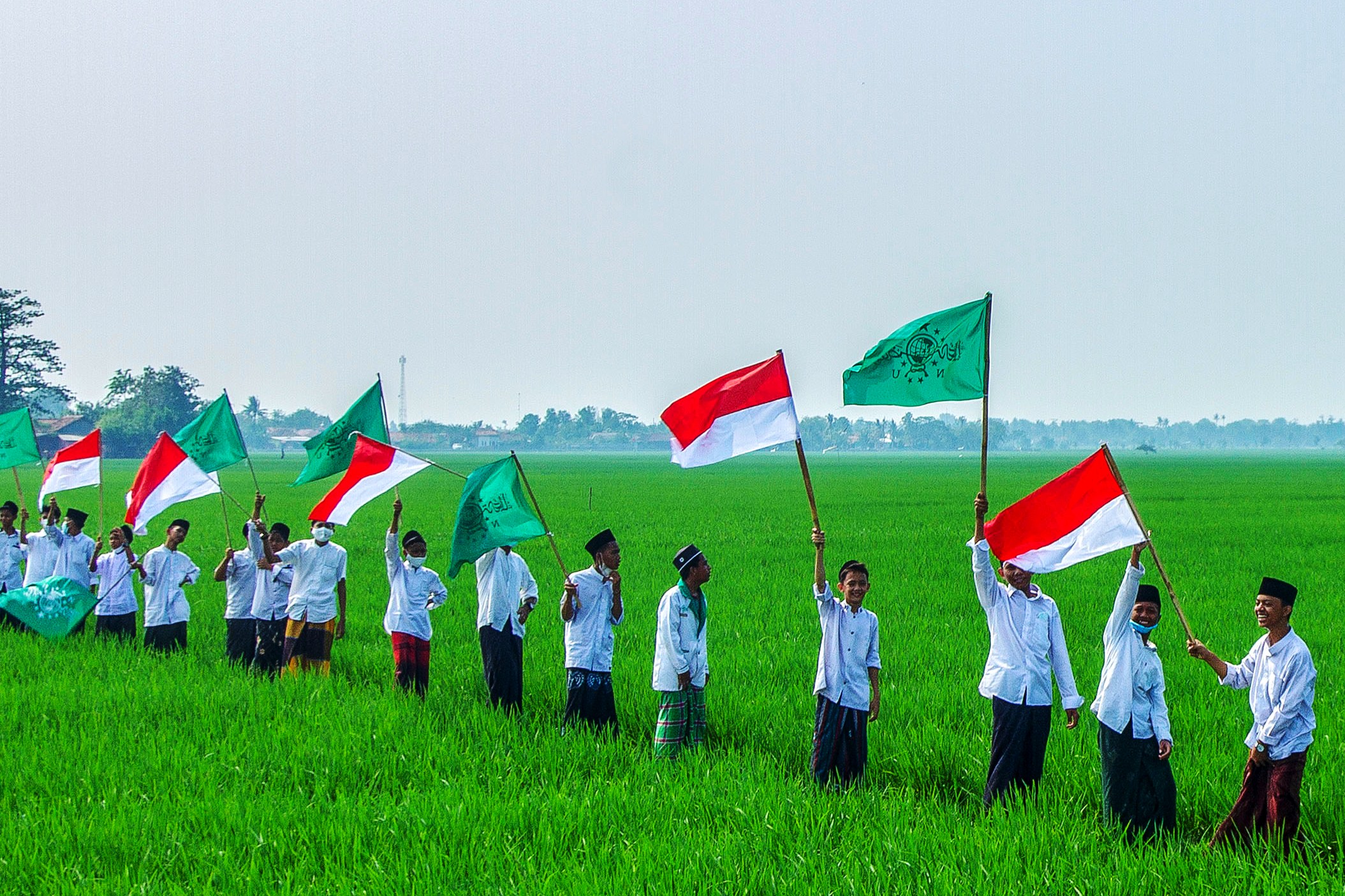  Santri mengibarkan bendera Merah Putih dan Nahdlatul Ulama