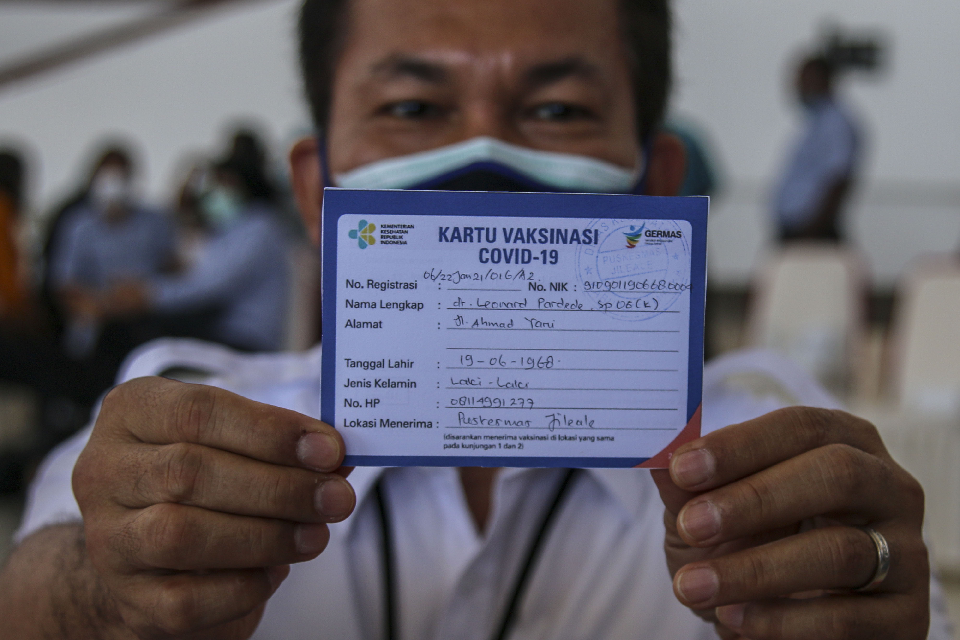 Ketua IDI Cabang Mimika Leonard Pardede menunjukkan kartu vaksinasi usai menerima vaksin covid-19 Sinovac di Mimika,Papua, Jumat (22/1/2021)