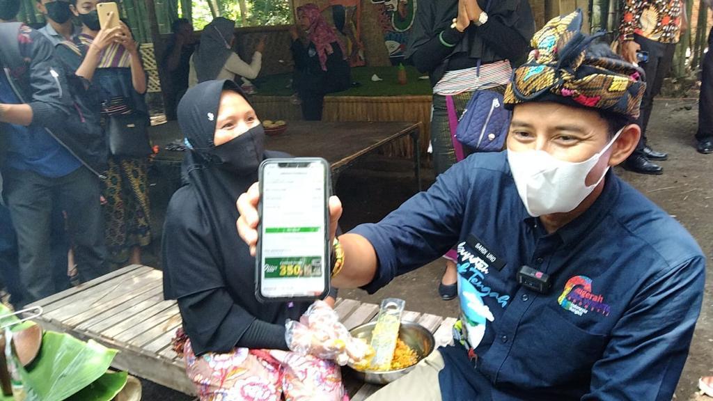 Menparekraf Sandiaga Uno membelikan peralatan untuk penjual jamu saat mengunjungi Desa Wisata Bonjeruk, Kecamatan Jonggat, Lombok, NTB. 