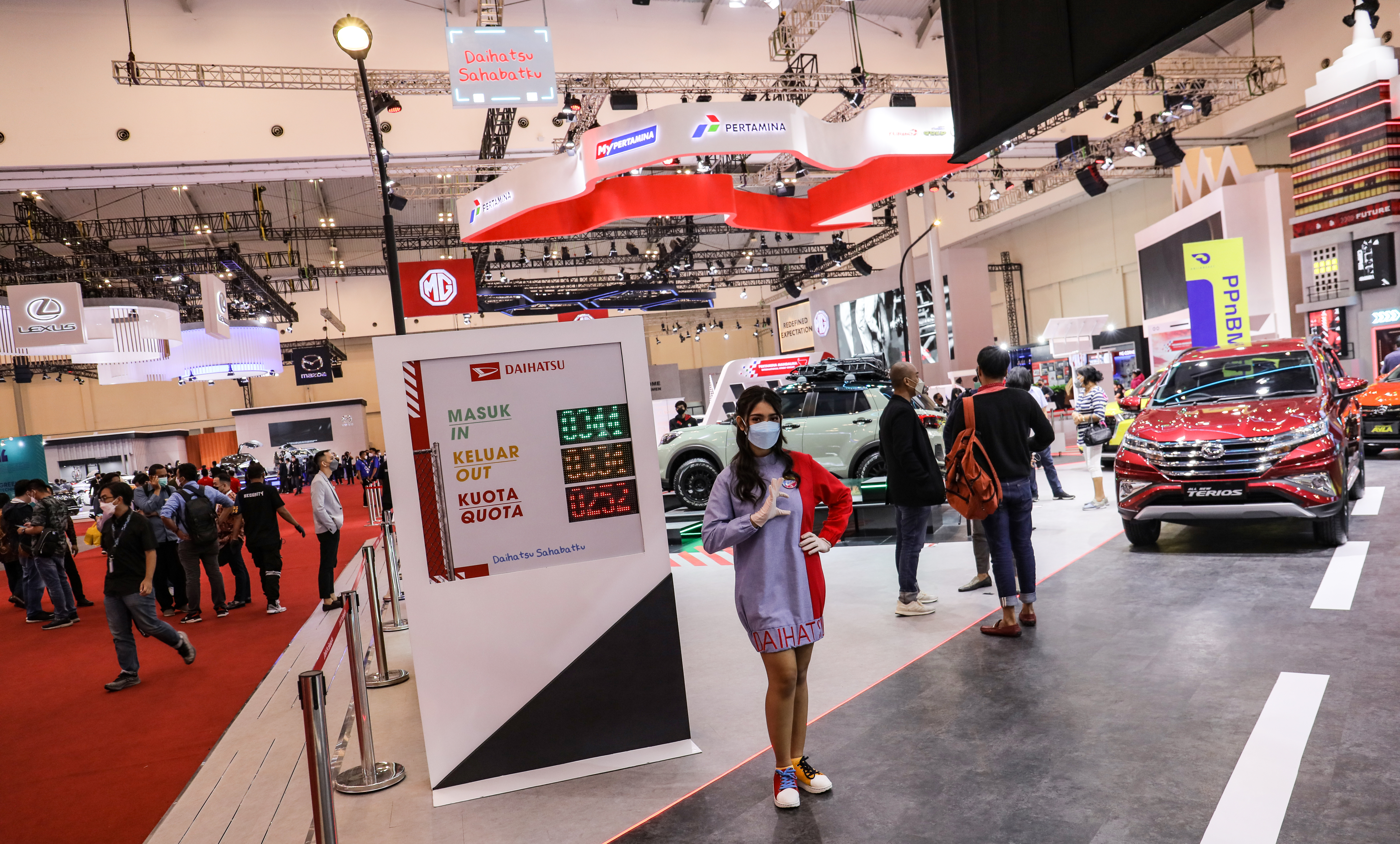 Papan petunjuk pembatasan jumlah pengunjung terpasang di pintu masuk stan mobil Daihatsu pada pameran GIIAS 2021.