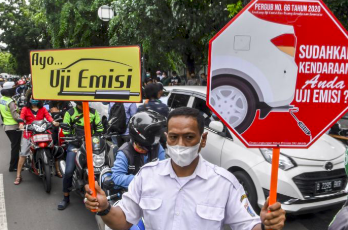Petugas sosialisasikan pemeriksaan uji emisi gas buang kendaraan bermotor di Jalan Pemuda, Jakarta.