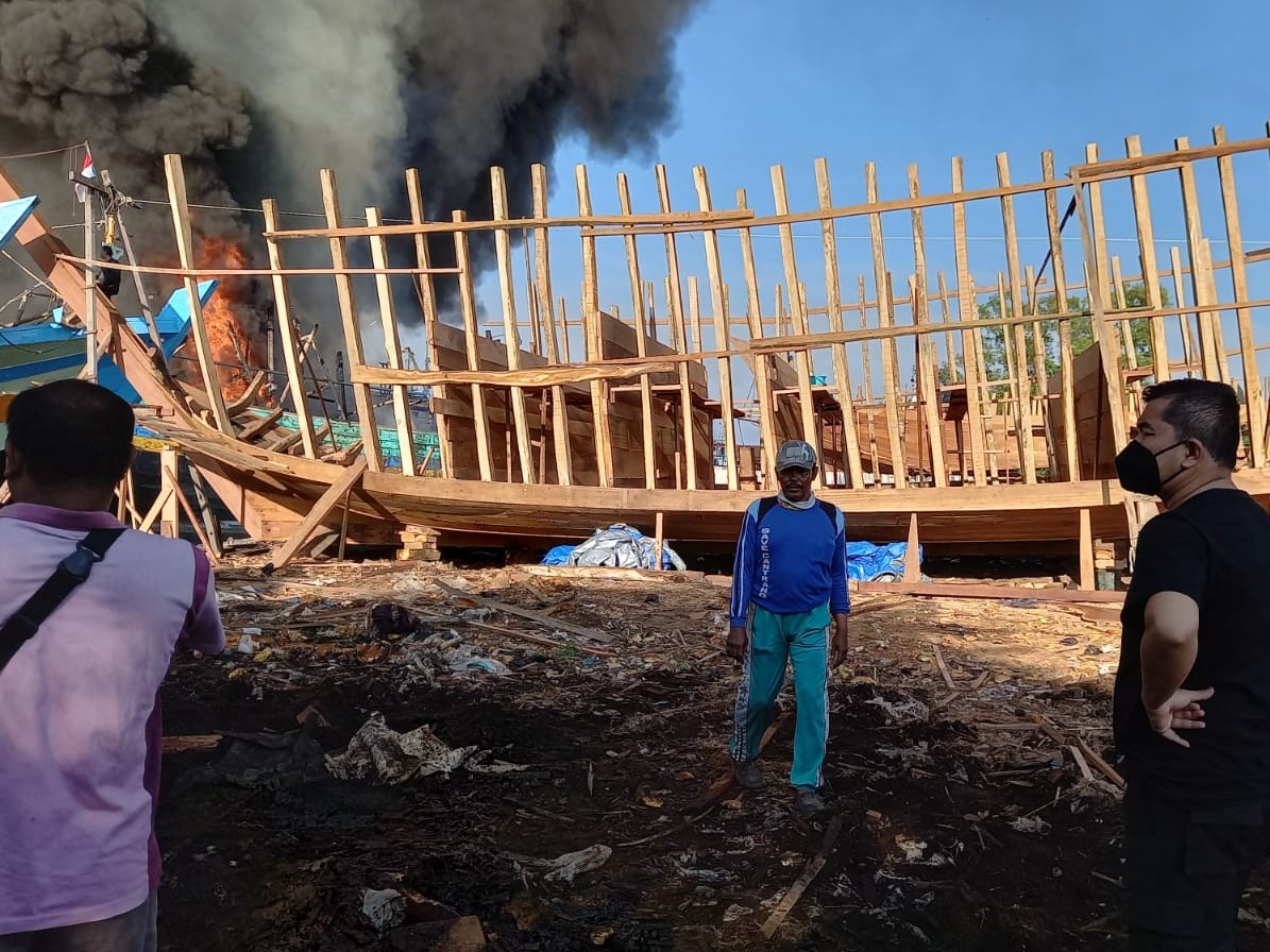 Kapolres Tegal Kota Ajun Komisaris Besar Rahmad Hidayat (kaos hitam) menyaksikan kobaran api kapal yang terbakar.