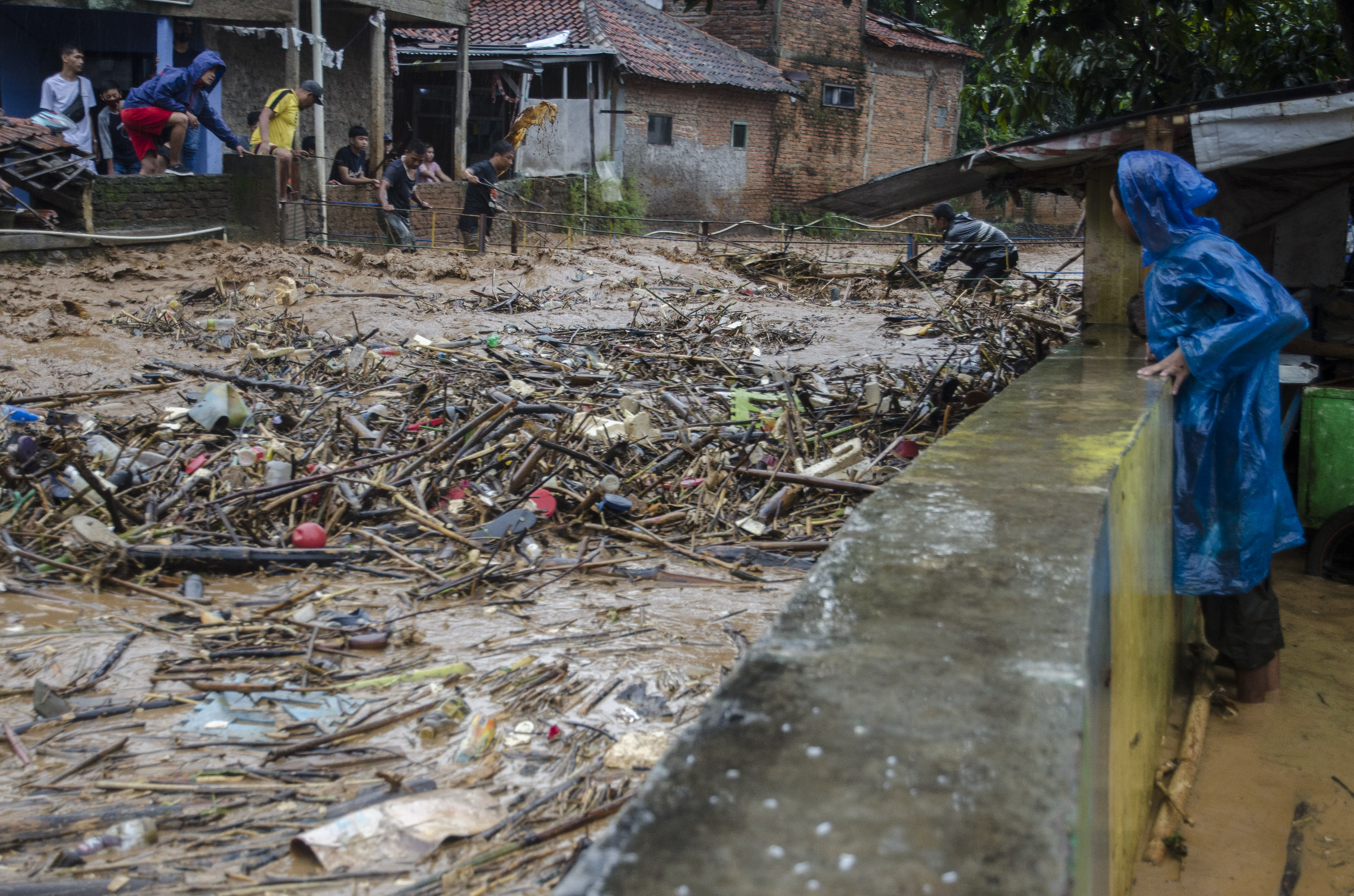Warga membongkar jembatan penghubung yang dipenuhi sampah di sungai Cipagalo yang meluap di Kawasan Sukamiskin, Bandung, Jumat (26/11/2021)