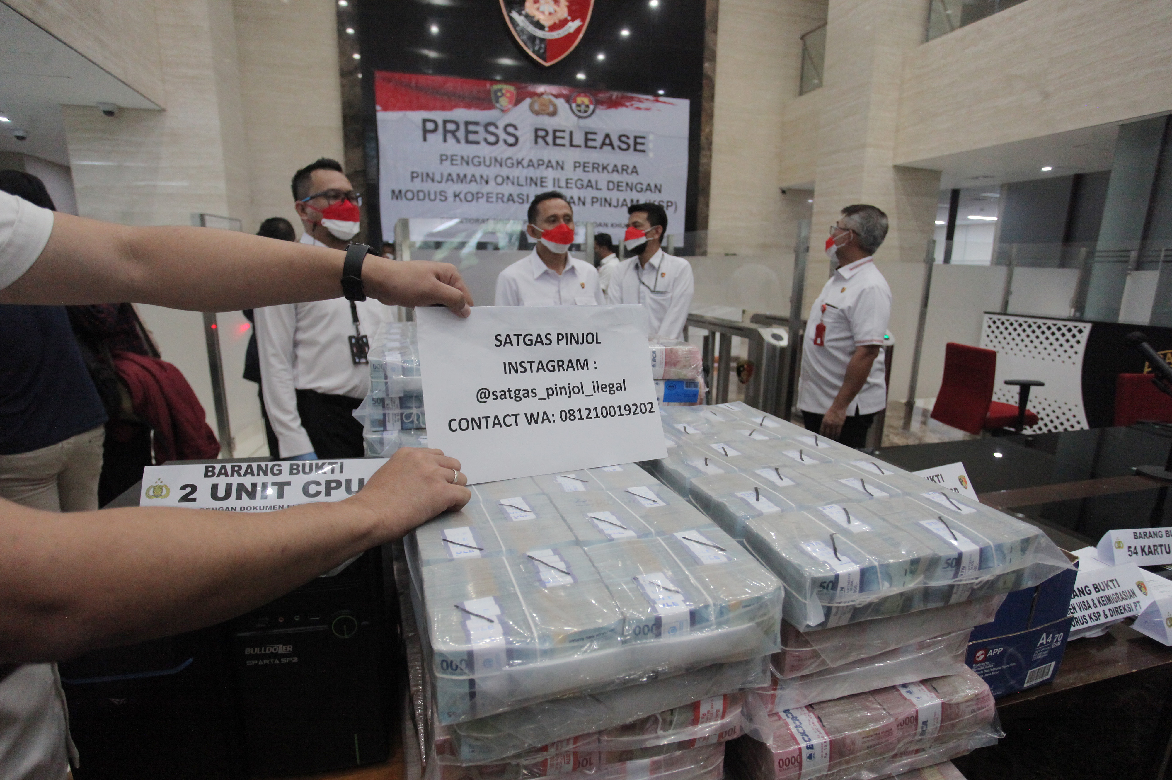 Polisi menunjukkan barang bukti kasus pinjaman online ilegal di Bareskrim Mabes Polri, Jakarta, Senin (25/10/2021).