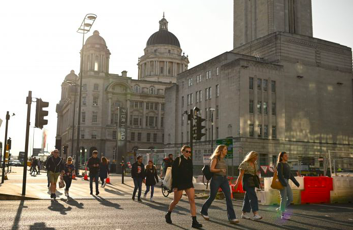 Sejumlah warga berjalan tanpa masker di wilayah Liverpool, Inggris.