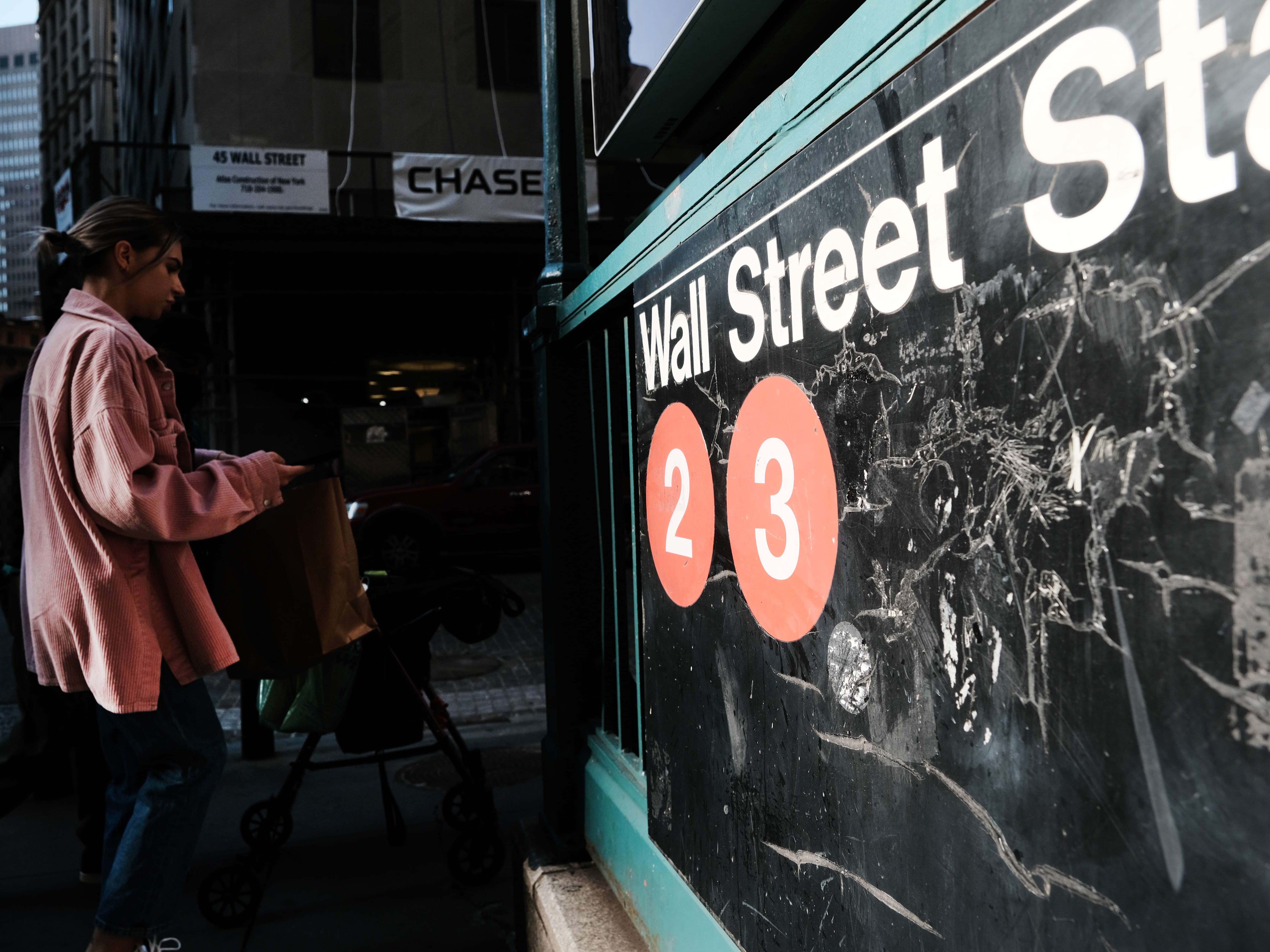Orang-orang berjalan di sepanjang Wall Street di luar New York Stock Exchange (NYSE).
