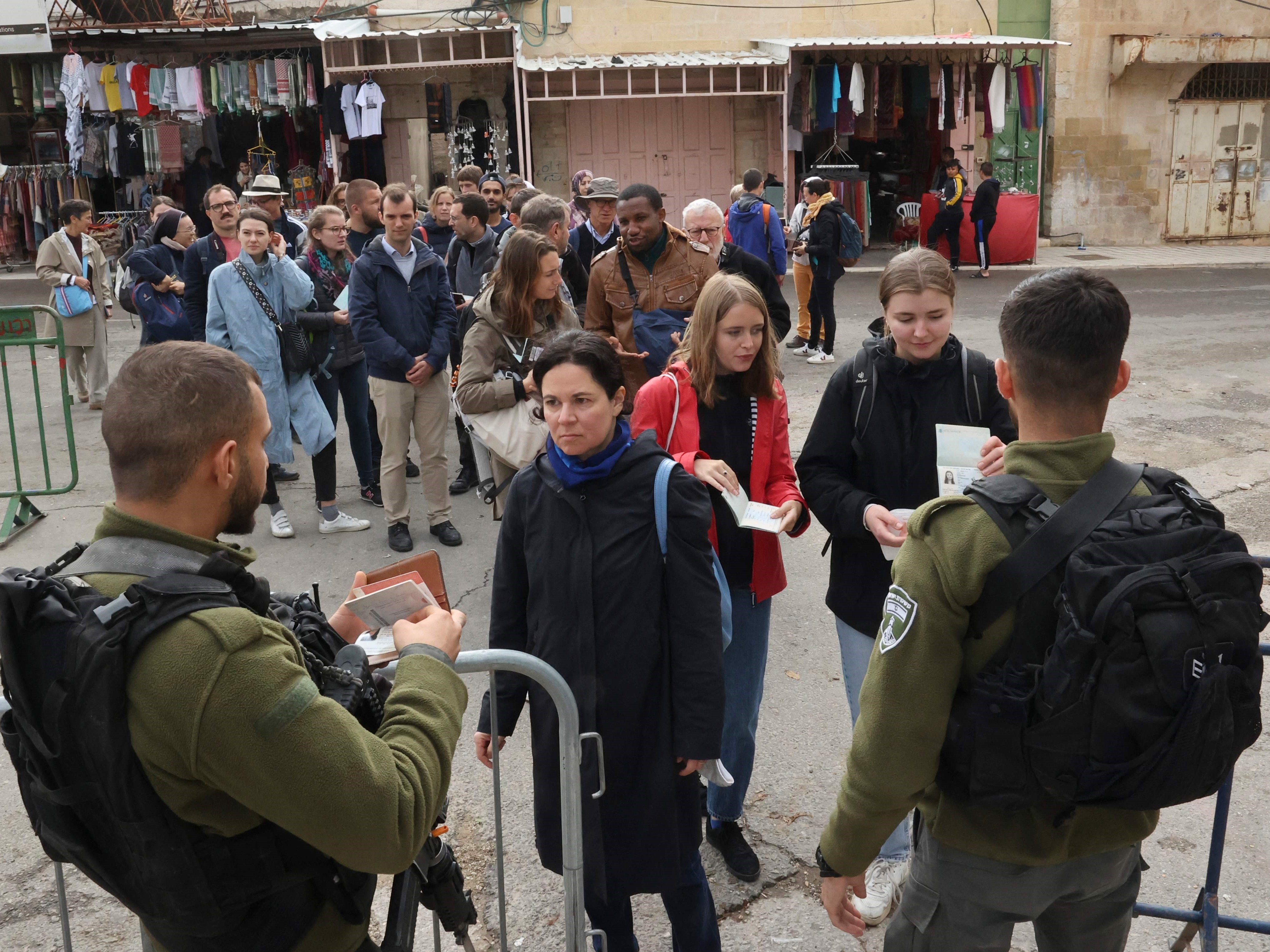 Polisi perbatasan Israel memeriksa paspor turis Prancis dalam perjalanan mereka untuk mengunjungi area Muslim Masjid Ibrahimi yang terbagi.