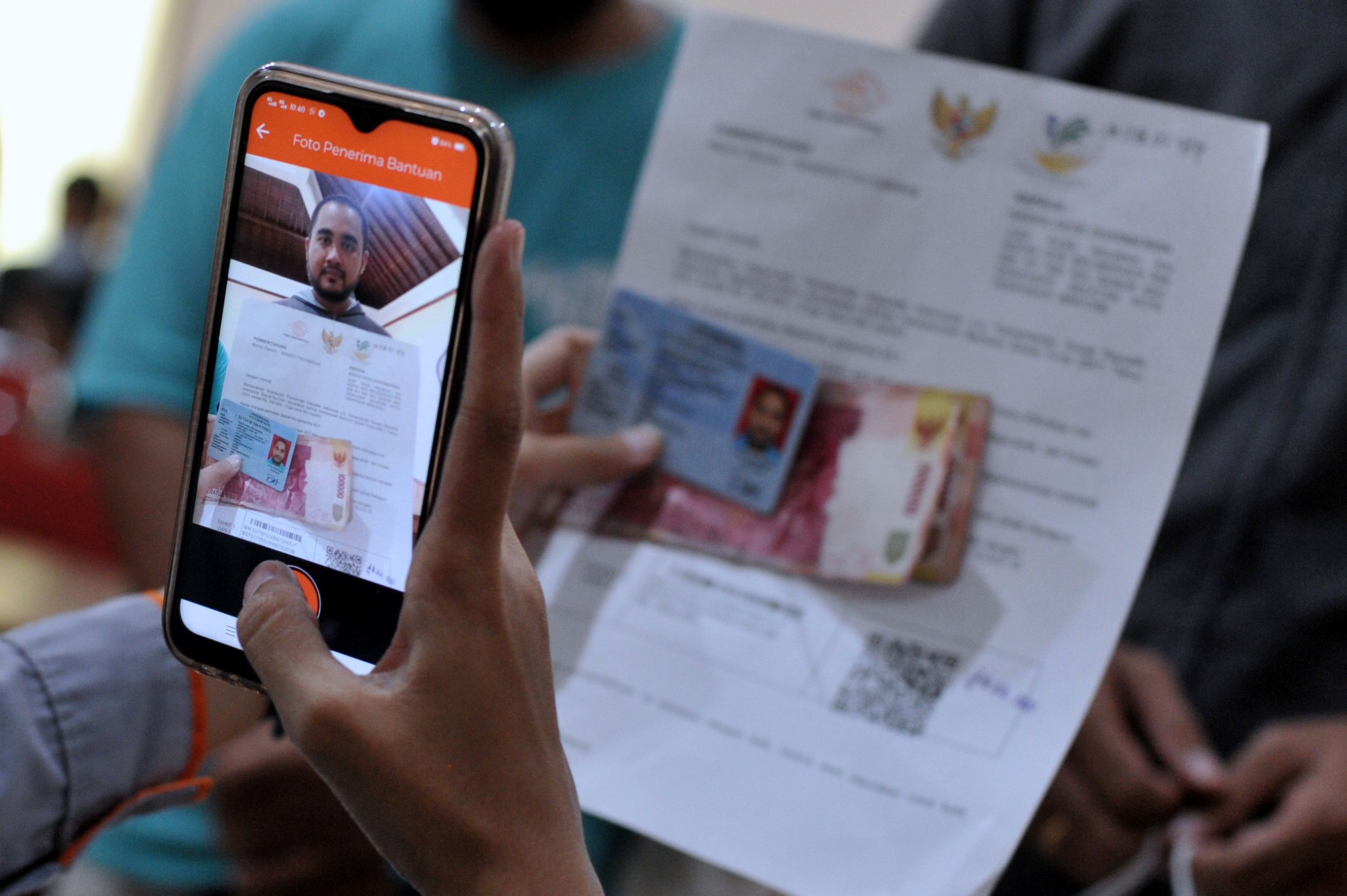 Petugas memotret penerima Bantuan Sosial Tunai (BST) saat pembayaran BST di kawasan Sanur, Denpasar, Bali
