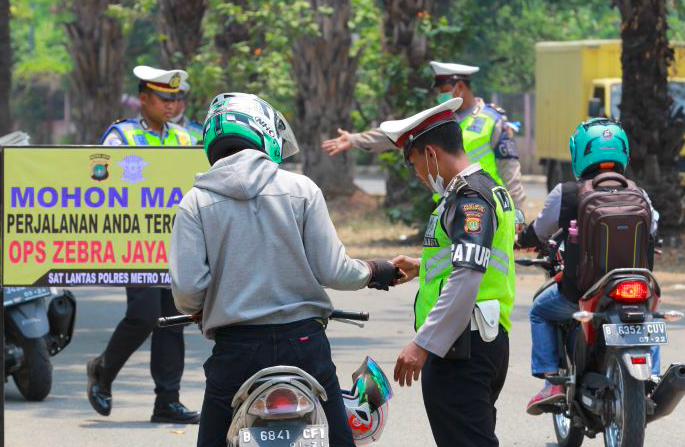 Petugas Polantas Polres Metropolitan Tangerang memeriksa kelengkapan surat-surat kendaraan bermotor.