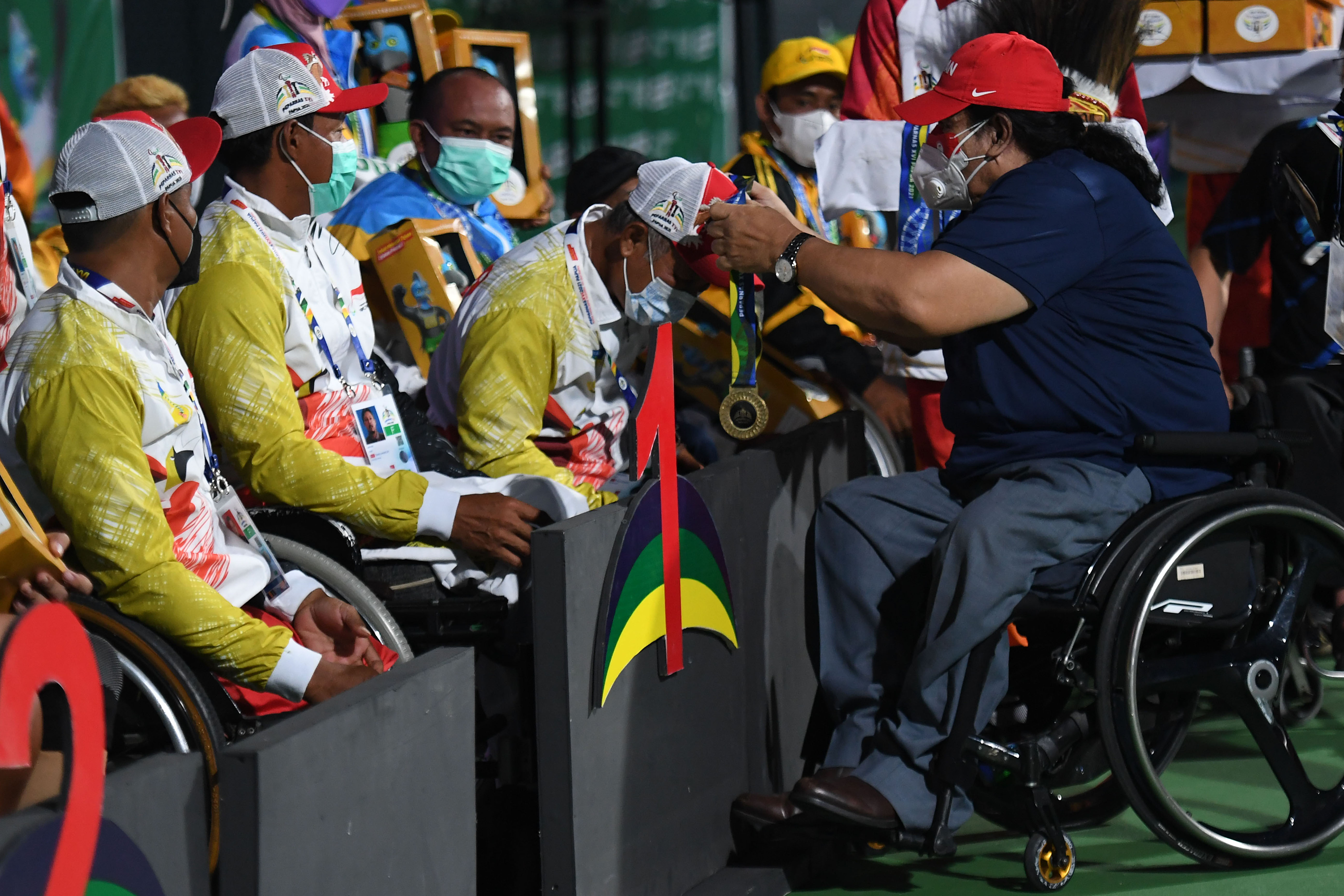 Ketua NPC Indonesia Seny Marbun (kanan) mengalungkan medali emas kepada tim tenis putra Papua di Peparnas XVI Papua.