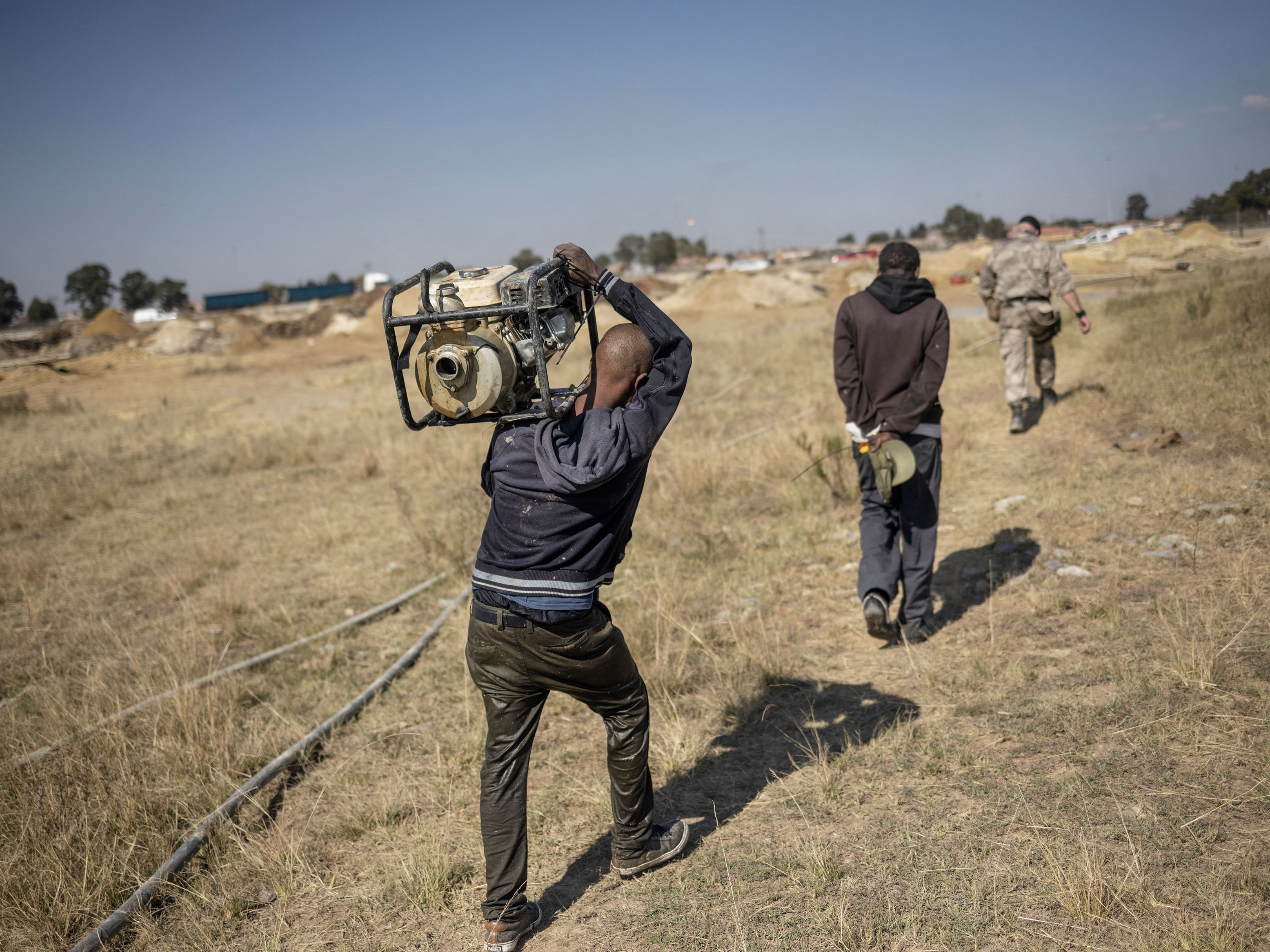 Personel keamanan dari perusahaan keamanan swasta Blue Hawk Tactical mengawal dua tersangka penambang ilegal.