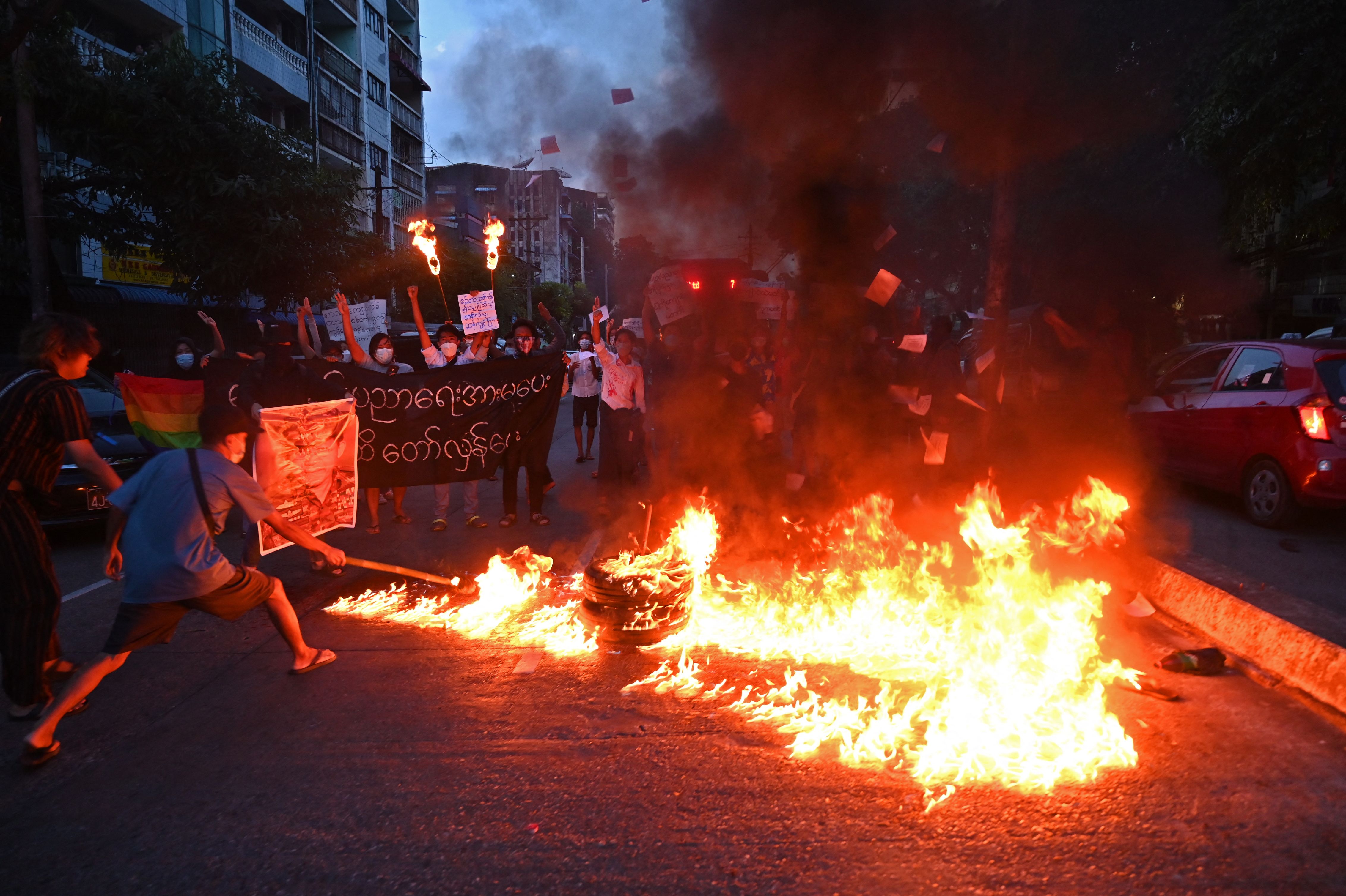 Demonstran membakar foto pemimpin junta militer Myanmar Min Aung Hlaing dalam aksi demonstrasi di Yangon.
