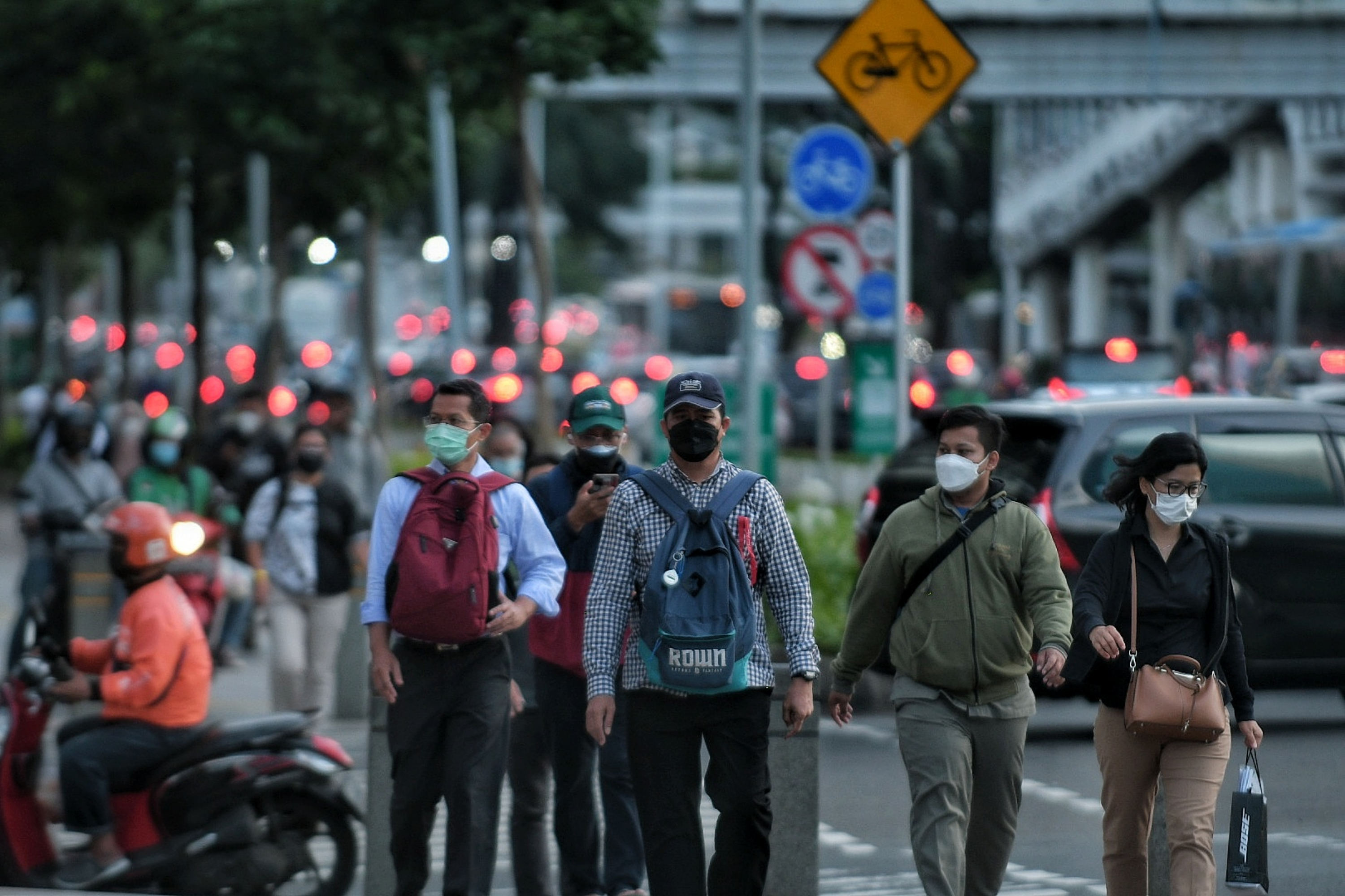 Pekerja berjalan di trotoar Jalan Jenderal Sudirman, Jakarta