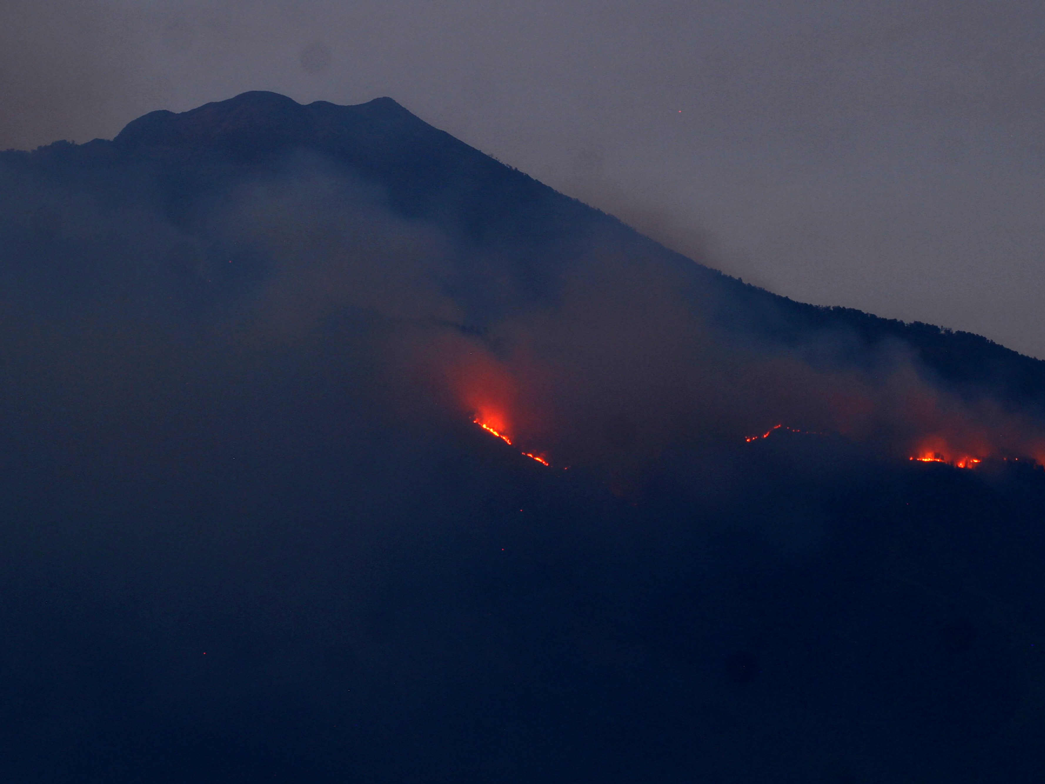 Api membakar hutan di lereng Gunung Arjuno terlihat dari Desa Landungsari, Malang, Jawa Timur, Jumat (11/10/2019).