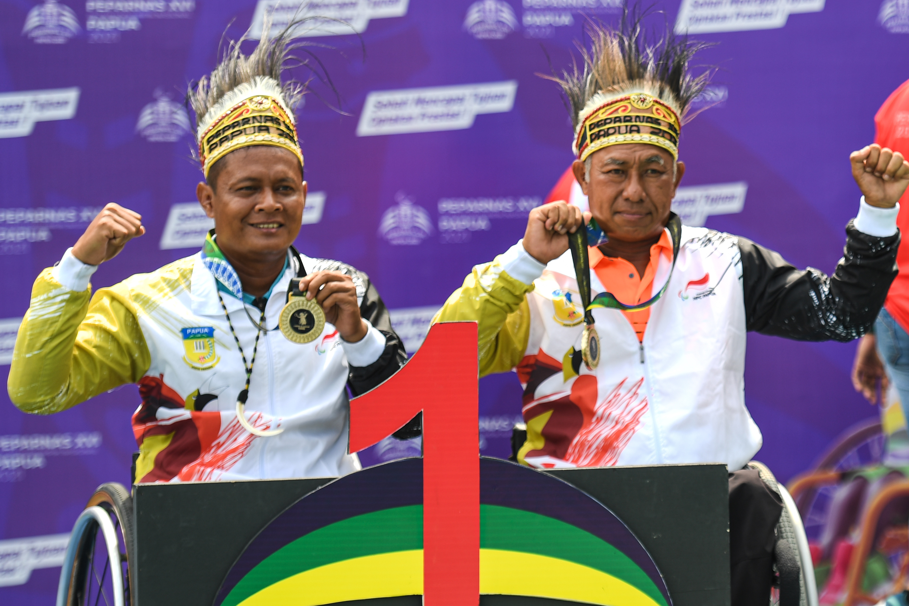 Petenis Papua Daryoko dan Erwin Subrata menunjukkan medali emas yang didapatkannya di ajang Peparnas XVI Papua
