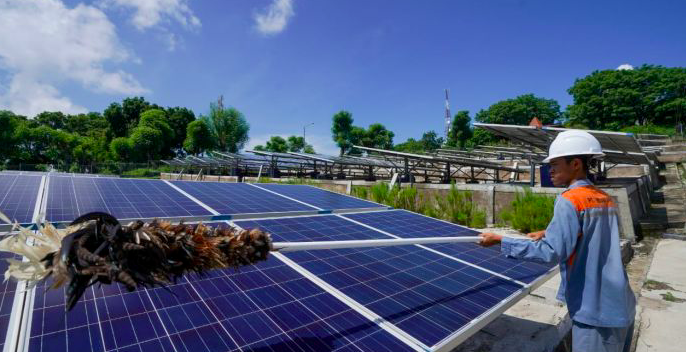 Petugas membersihkan panel surya pada Pembangkit Listrik Tenaga Surya Gili Trawangan, Lombok, NTB. 
