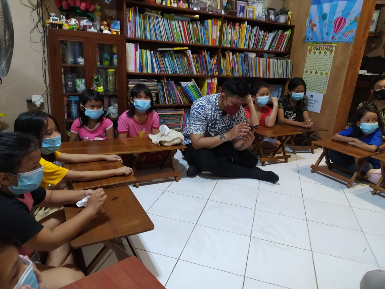 Staf dari Sudin Perpustakaan mendongeng di hadapan anak-anak di TBM Bukit Duri Bercerita di kawasan Bukit Duri Tanjakan, Jaksel. 