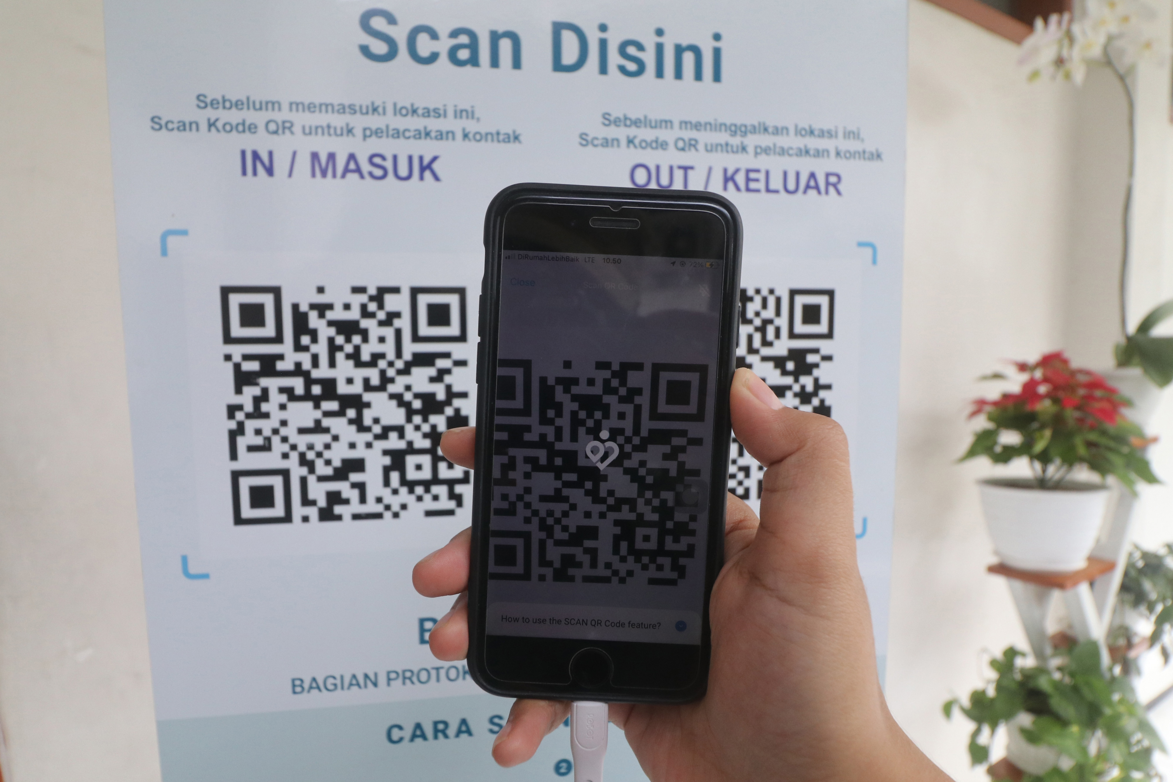  APLIKASI PEDULI LINDUNGI: Seorang pengunjung memindai kode batang (QR Code) melalui aplikasi PeduliLindungi di pusat keramaian.