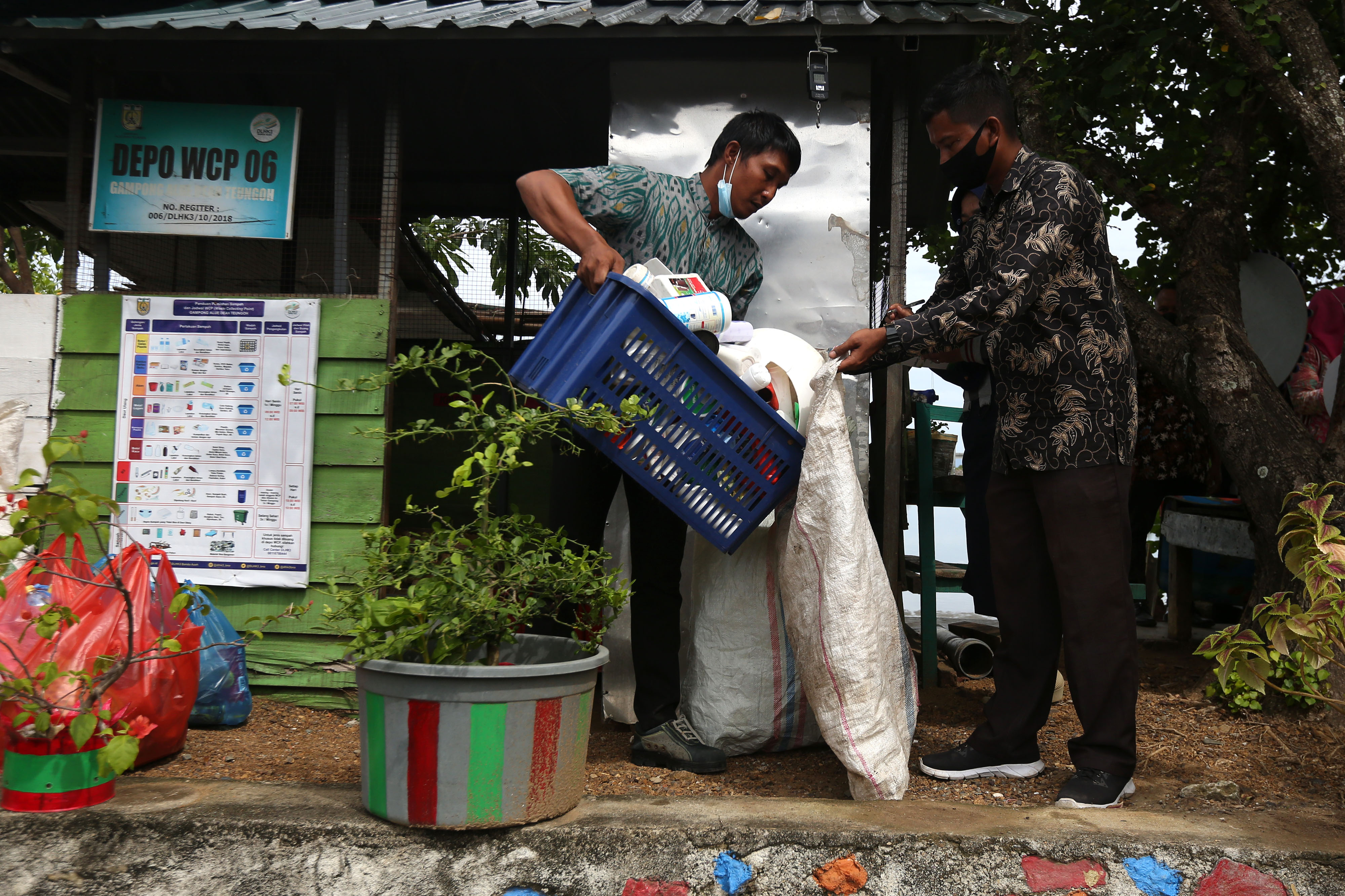 Petugas memilah sampah plastik rumah tangga yang dapat didaur ulang di tempat pengumpulan sampah  Desa Alue Deah Teungoh, Banda Aceh, Aceh.