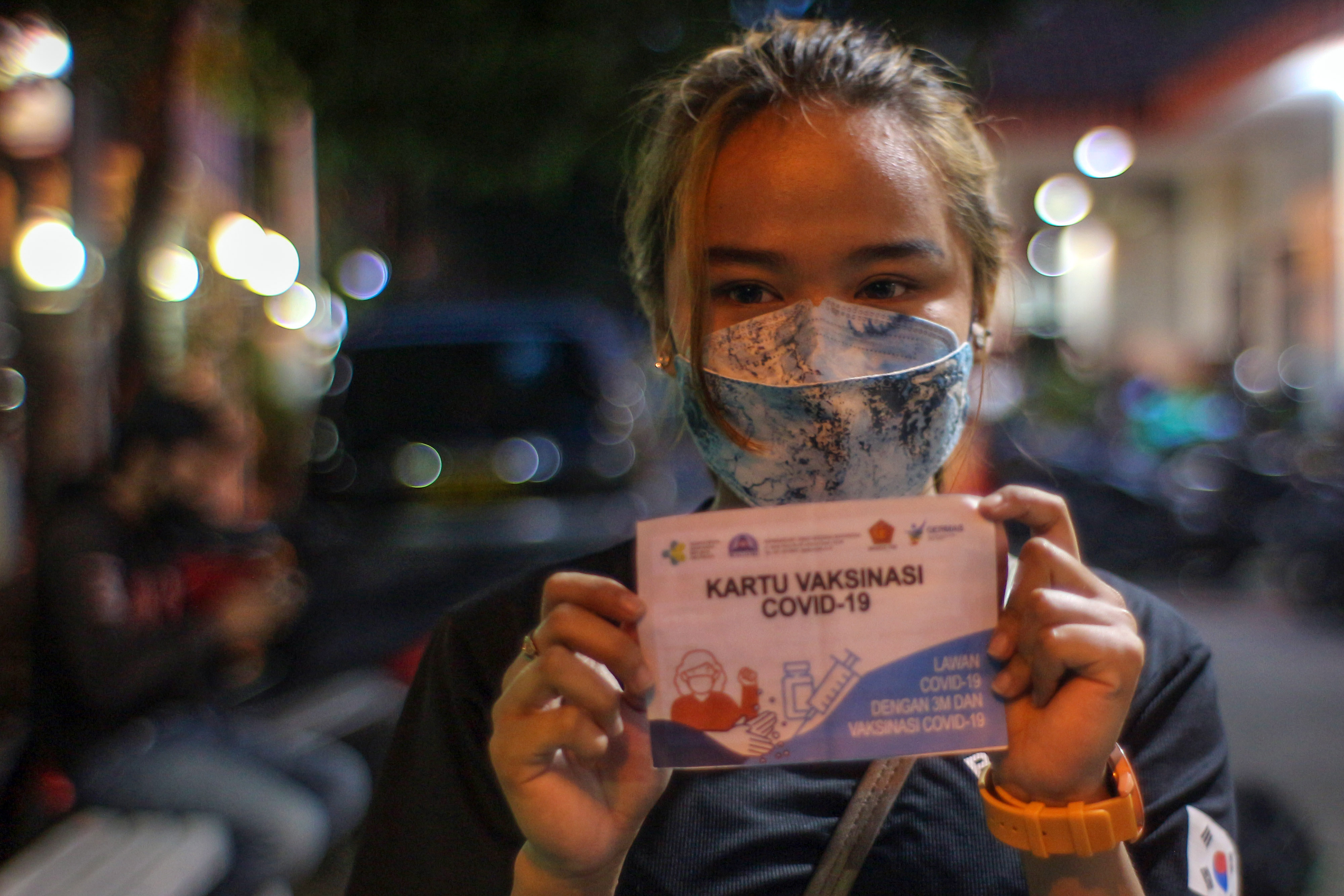 Warga menunjukkan kartu vaksin covid-19 setelah melakukan vaksinasi di Polsek Cibinong, Kabupaten Bogor, Jawa Barat, Senin (15/11/2021)