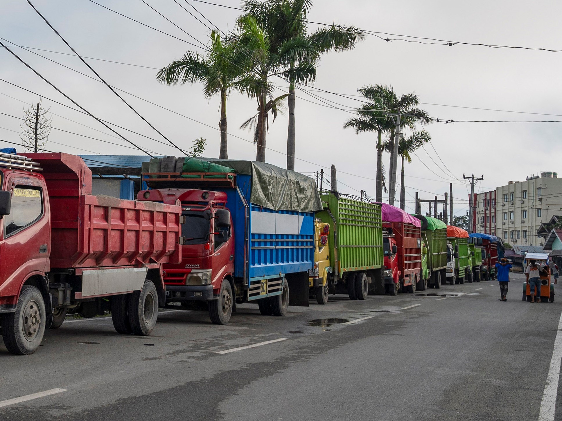Pengumpul barang bekas melintas di dekat barisan antrean truk mengisi bahan bakar solar di SPBU, Palu, Sulawesi Tengah, Rabu (1/9).