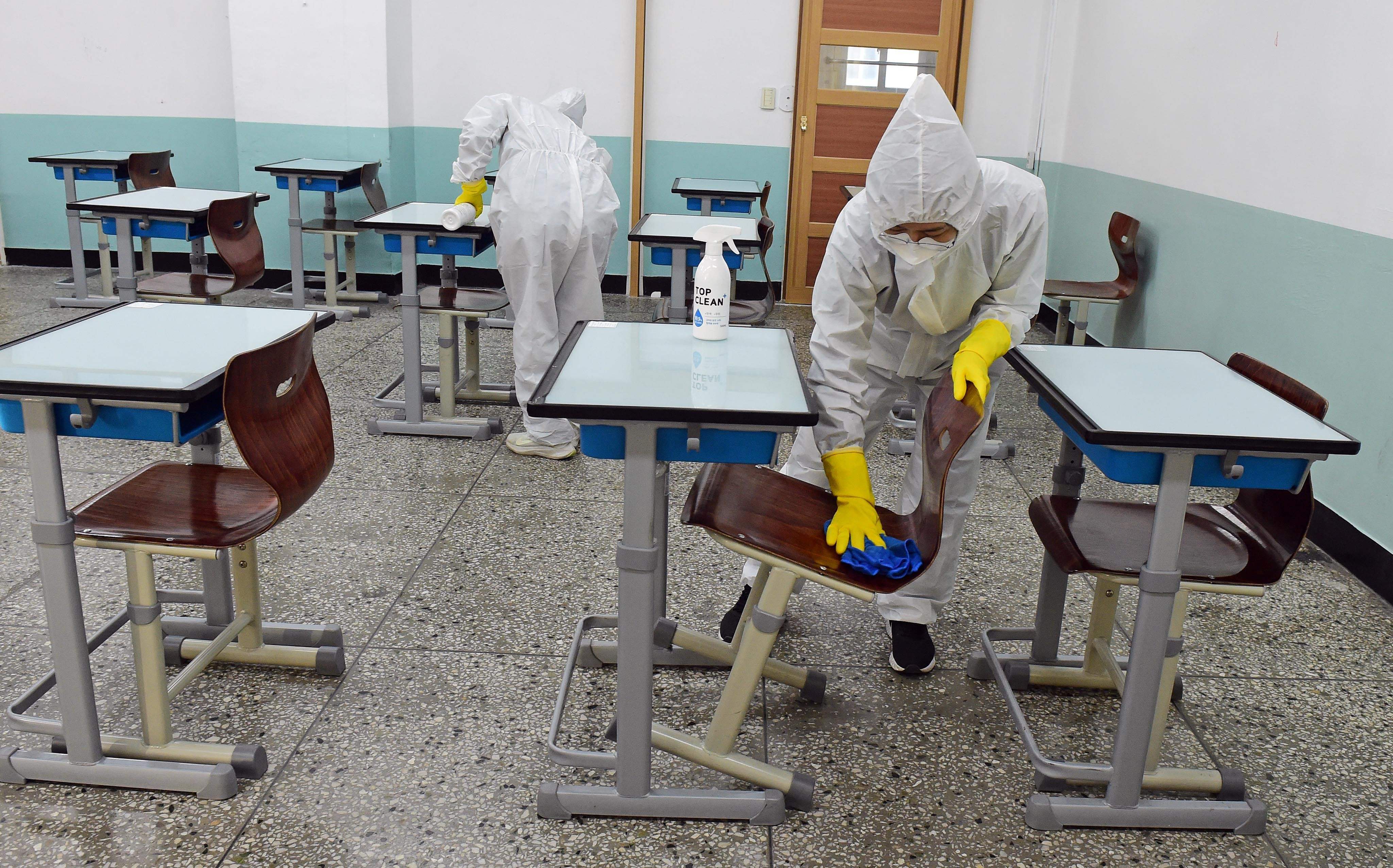 Petugas membersihkan ruang kelas dengan disinfentan di sebuah sekolah di Seoul, Korea Selatan, Rabu (17/11).