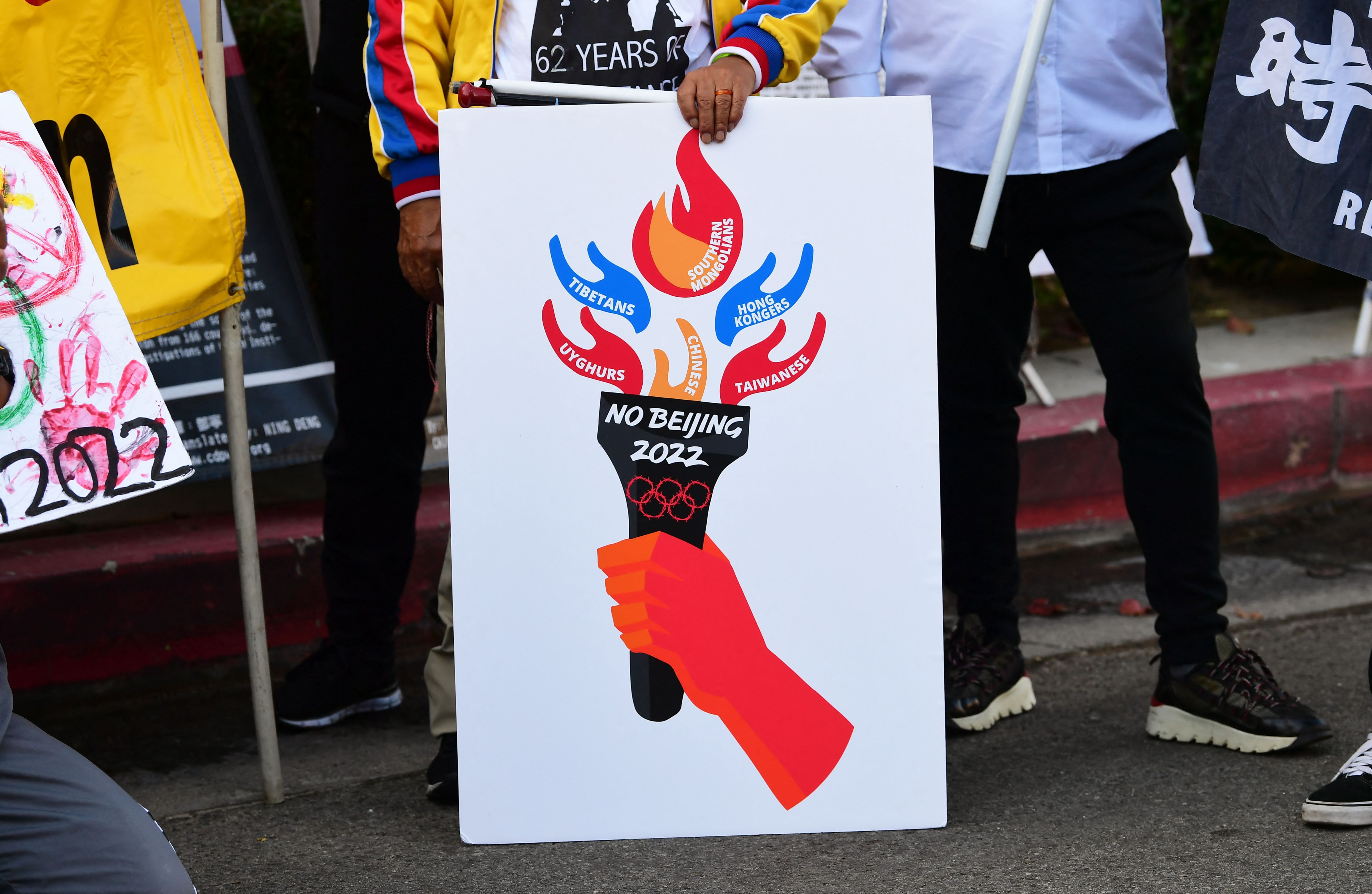 Dengan membawa poster Olimpiade Musim Beijing Dingin 2022, sejumlah aktivis meminta boikot saat unjuk rasa di Los Angeles, AS. 