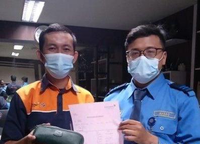 Petugas cleaning service Raynaldi (kiri) menunjukkan dompet yang ditemukannya. 