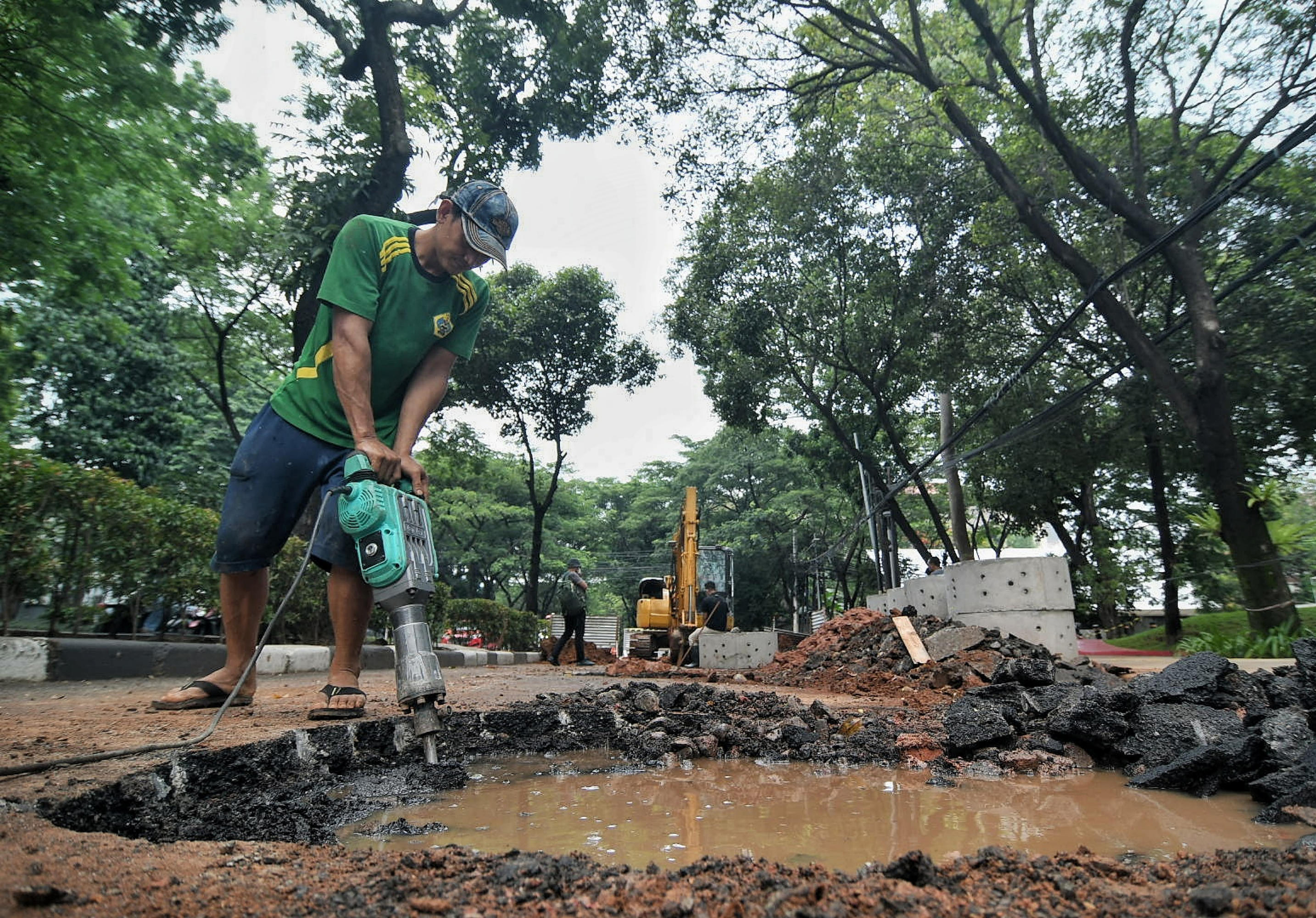 Pekerja sedang menyelesaikan pengerjaan sumur resapan di Jalan Mataram Raya, Kebayoran Baru, Jaksel, Selasa (12/10/2021)