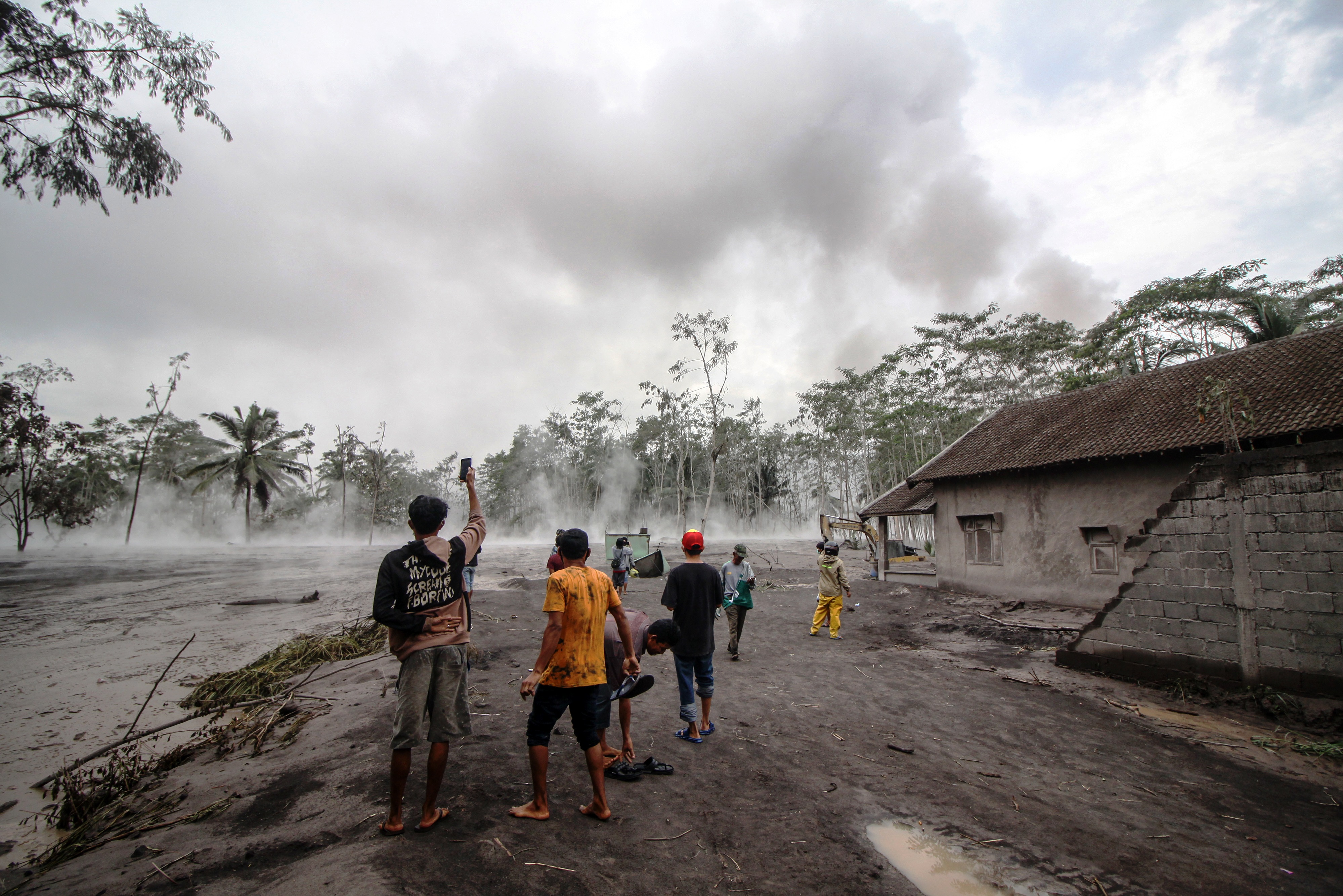 Warga melihat material awan panas erupsi Gunung Semeru yang mengalir di Sumber Wuluh, Lumajang, Jawa Timur, Minggu (5/12).
