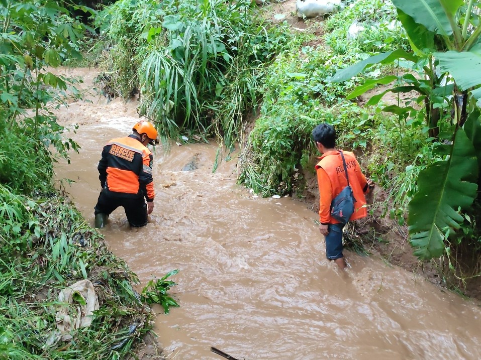 Relawan sedang melakukan penyisiran dua korban terbawa hanyut sungai Cikapundung, Kamis (23/12).