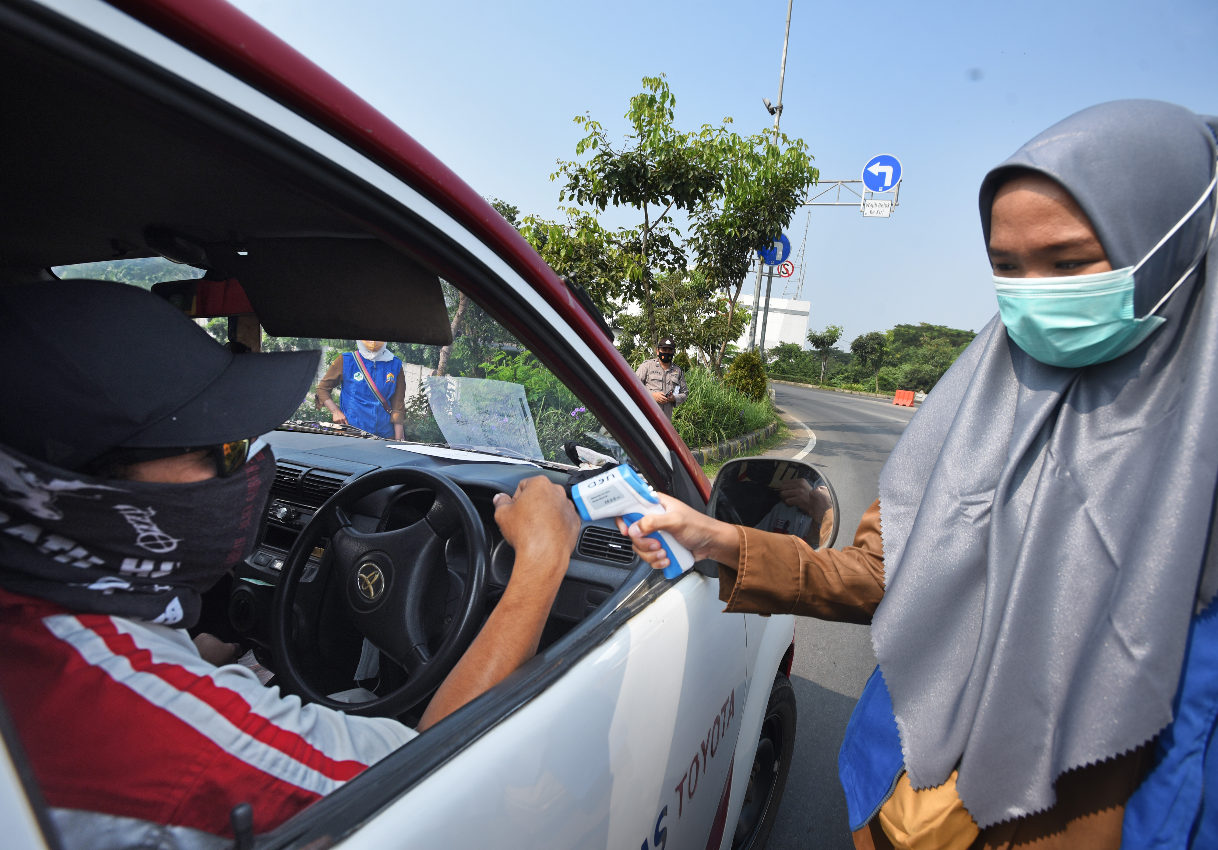 Petugas memeriksa suhu tubuh pengemudi di pintu tol Serang Timur, Banten