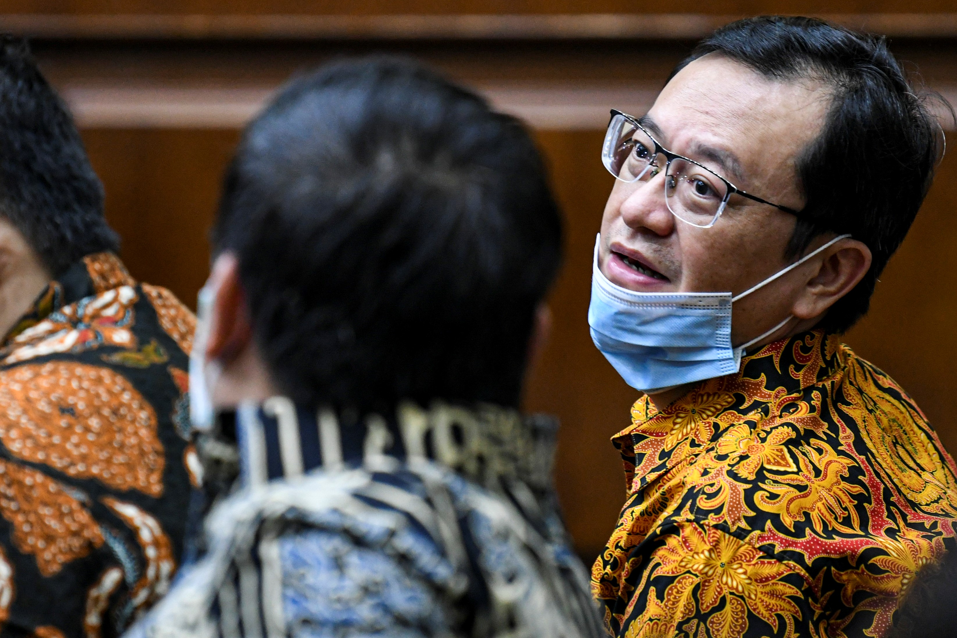 Terdakwa Direktur Utama PT Hanson Internasional Tbk Benny Tjokrosaputro (kanan) berbincang dengan Komut PT TRAM Heru Hidayat