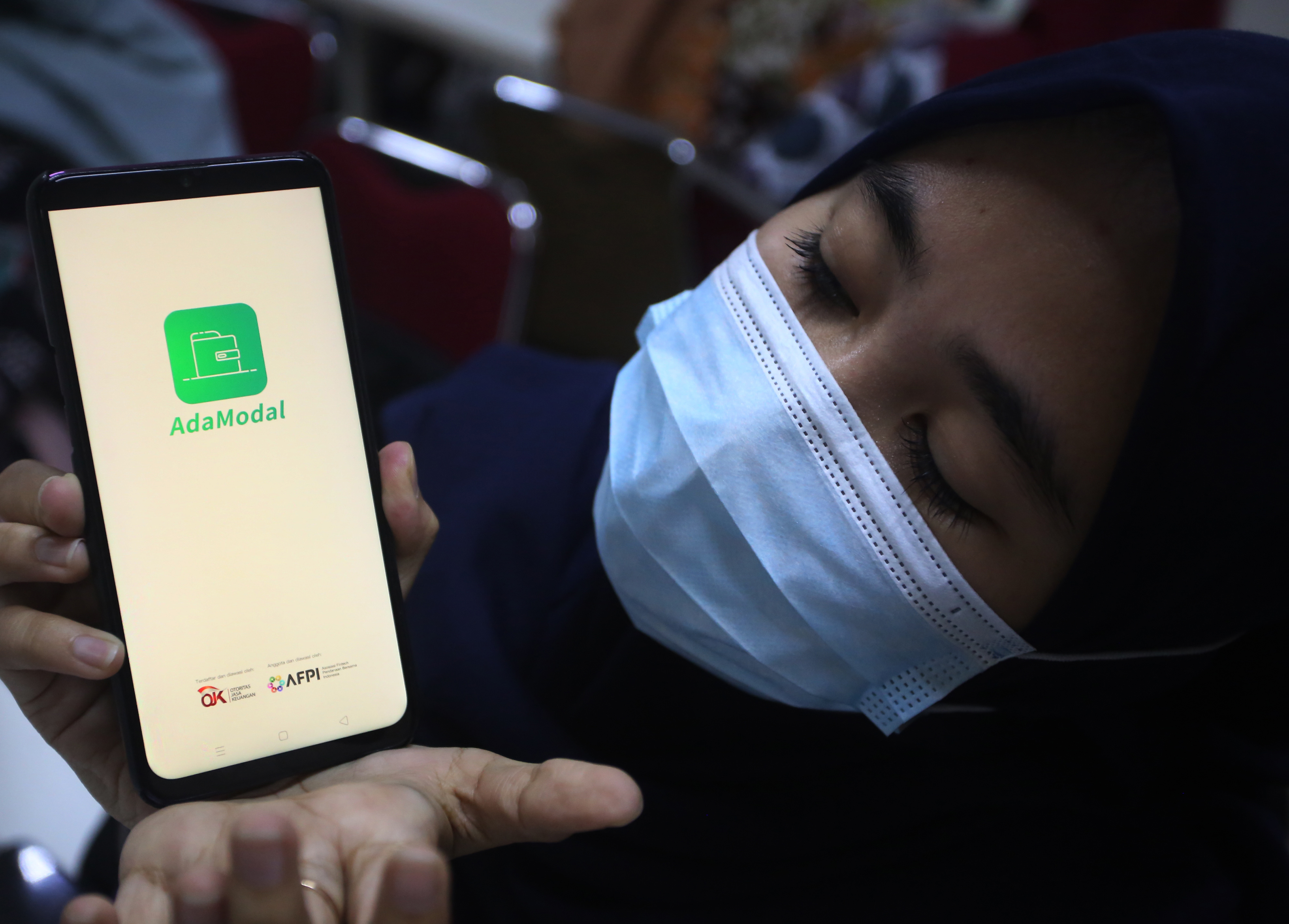 Pekerja menunjukan aplikasi pinjaman online ilegal.