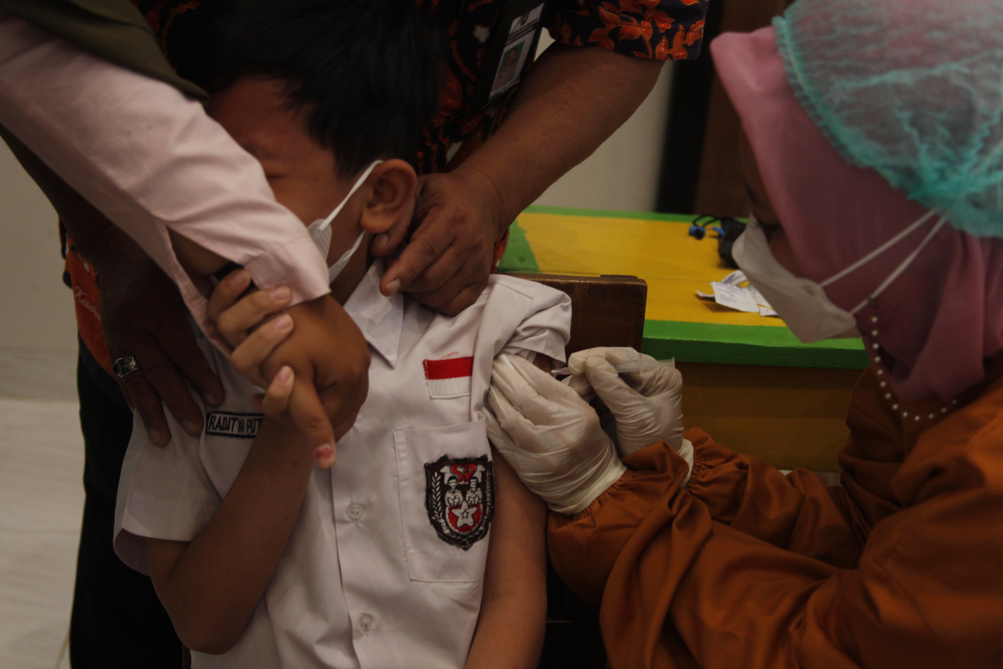 Petugas medis menyuntikkan vaksin covid-19 kepada siswa berusia 6-11 tahun di SD Negeri Kleco, Solo, Jawa Tengah, Selasa (21/12/2021)