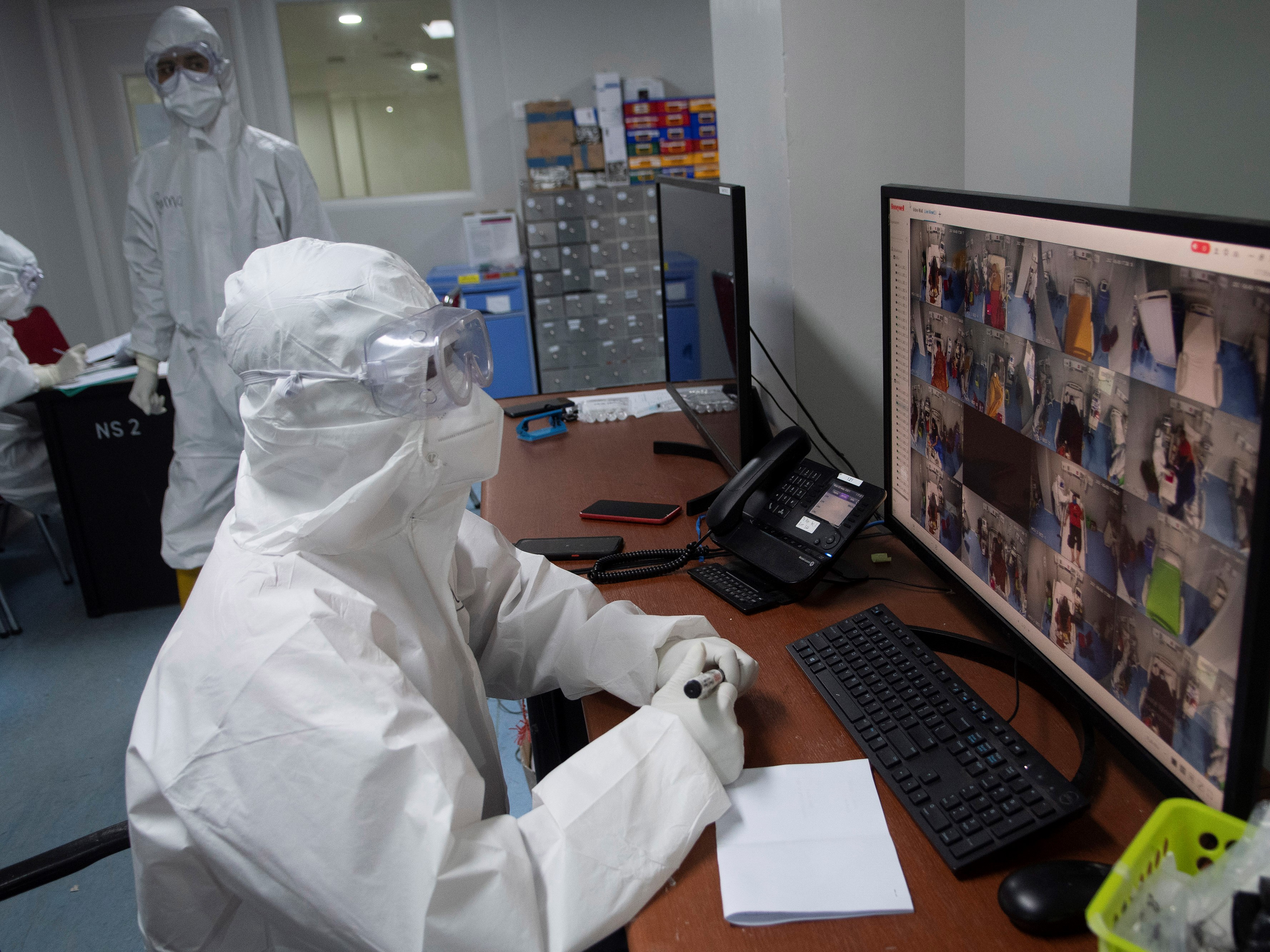  Tenaga kesehatan mengamati monitor kamera CCTV di ruang perawatan pasien di RSDC Wisma Atlet, Kemayoran, Jakarta, Rabu (5/5/2021).