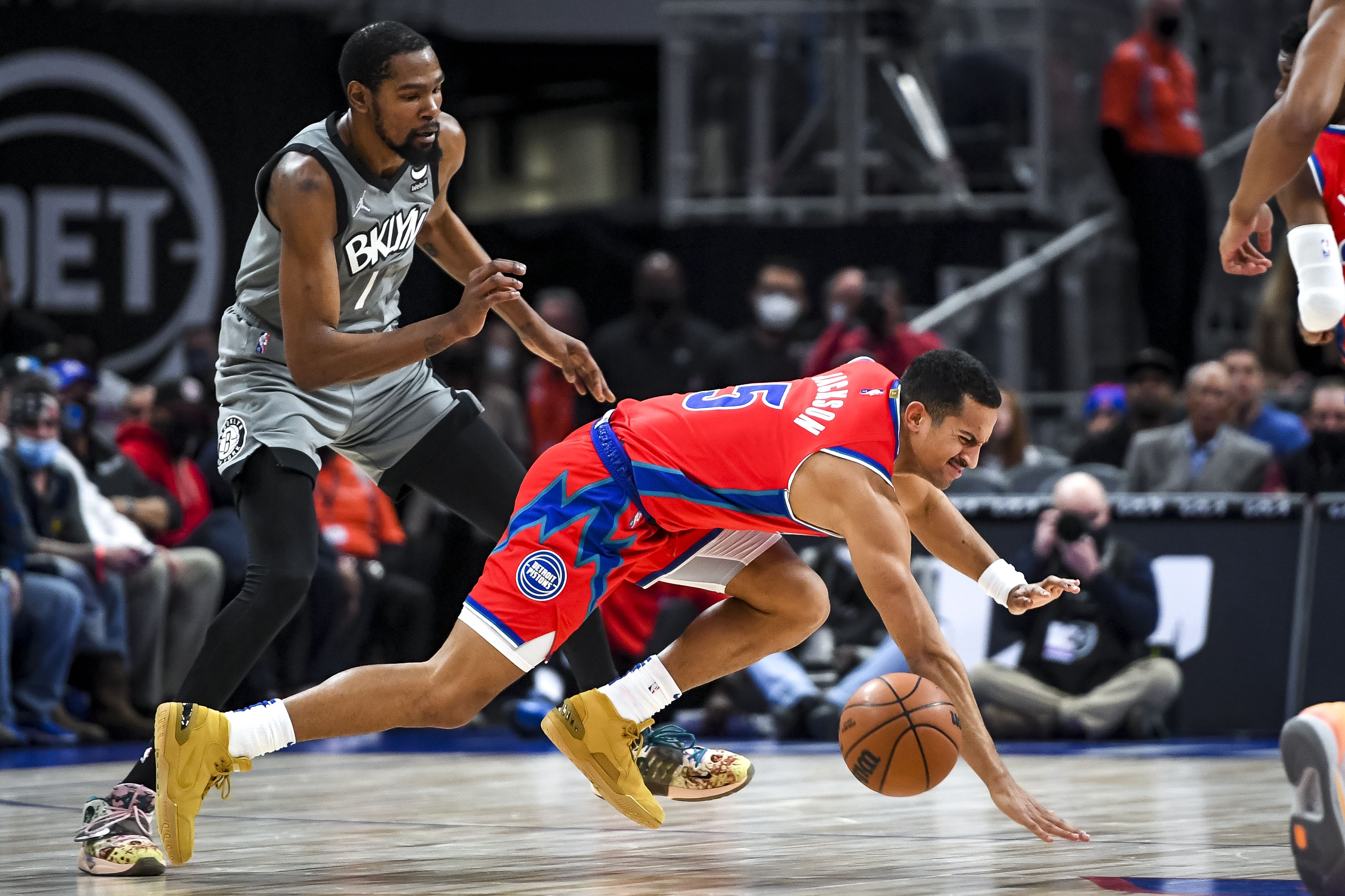Pemain Brooklyn Nets, Kevin Durant (kiri), mengawasi gerakan Frank Jackson dari Detroit Pistons yang terjatuh pada laga Liga NBA. 