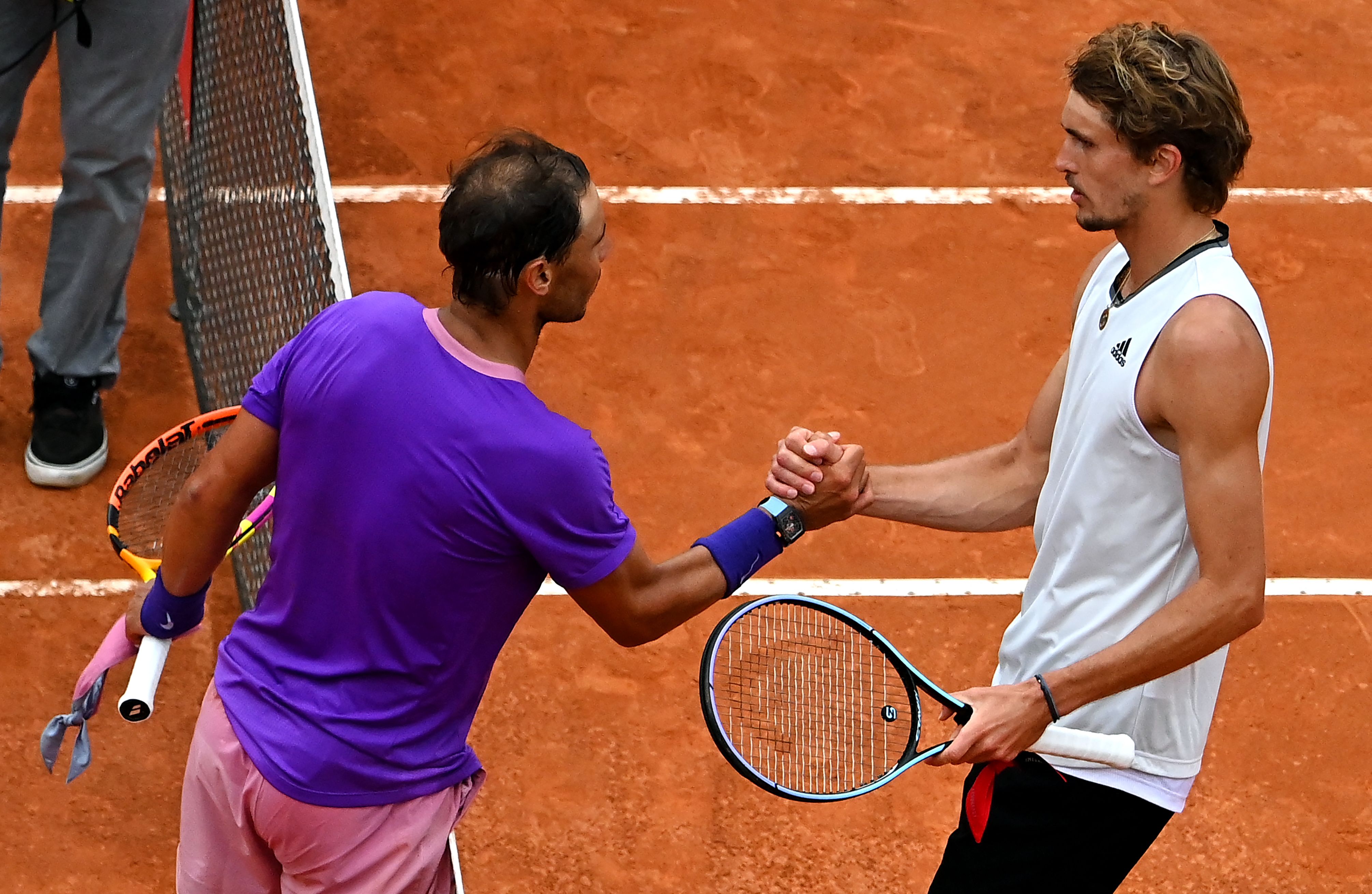 Alexander Zverev (kanan) bersalaman dengan legenda tenis Rafael Nadal