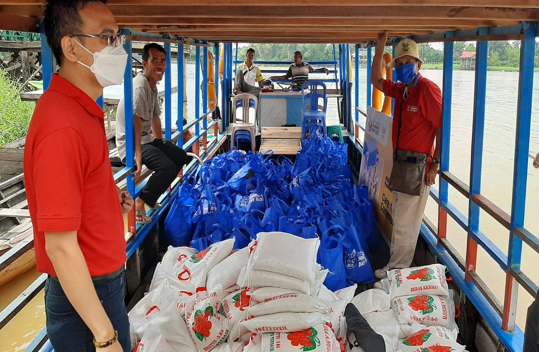 Karyawan Asian Agri mengantarkan bantuan sembako untuk warga