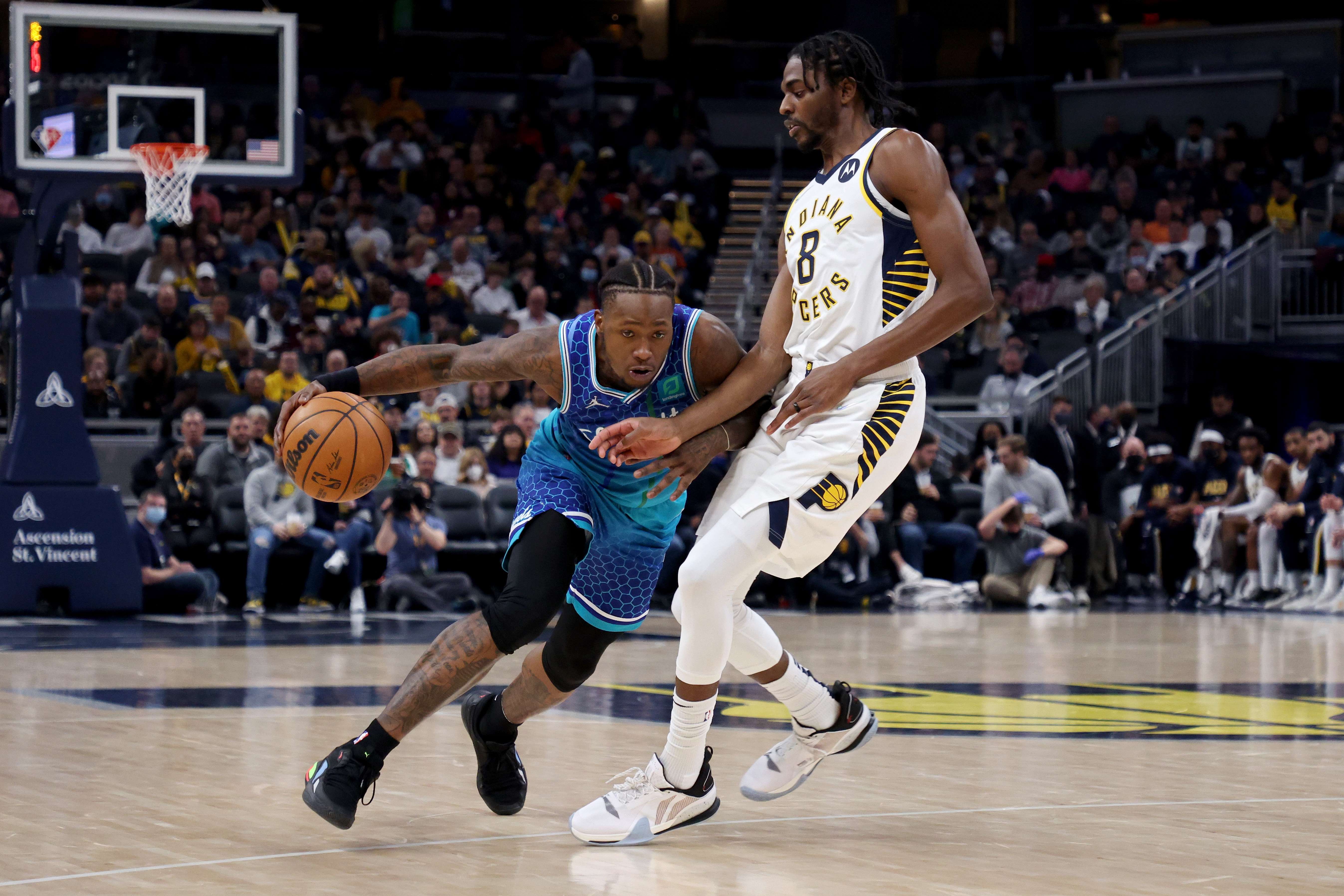 Pemain Charlotte Hornets Terry Rozier berusaha melewati hadangan pemain Indiana Pacers di laga NBA.