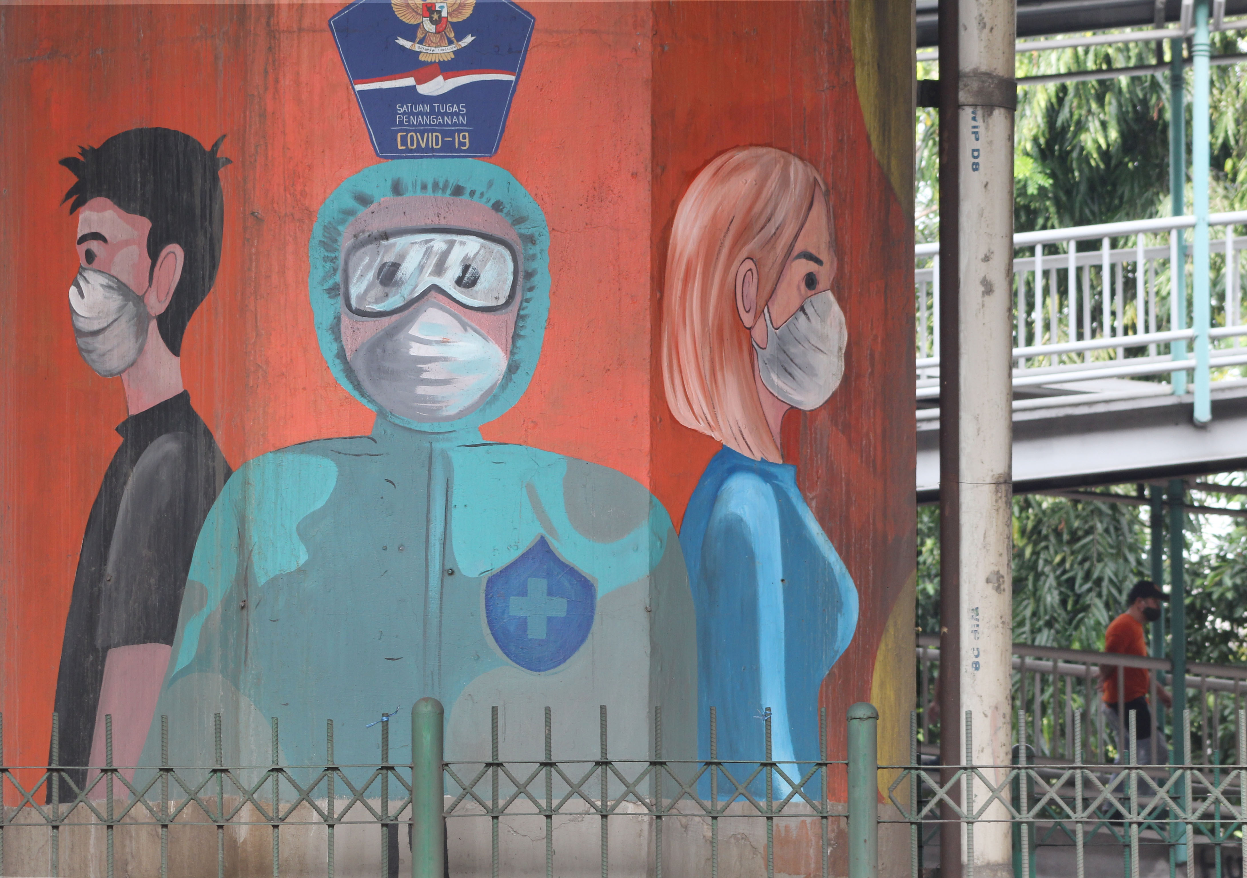 Mural edukasi dan sosialisasi protokol kesehatan untuk pemberantasan covid-19 terpanpang di tiang jalan Tol Layang di Jakarta Utara.