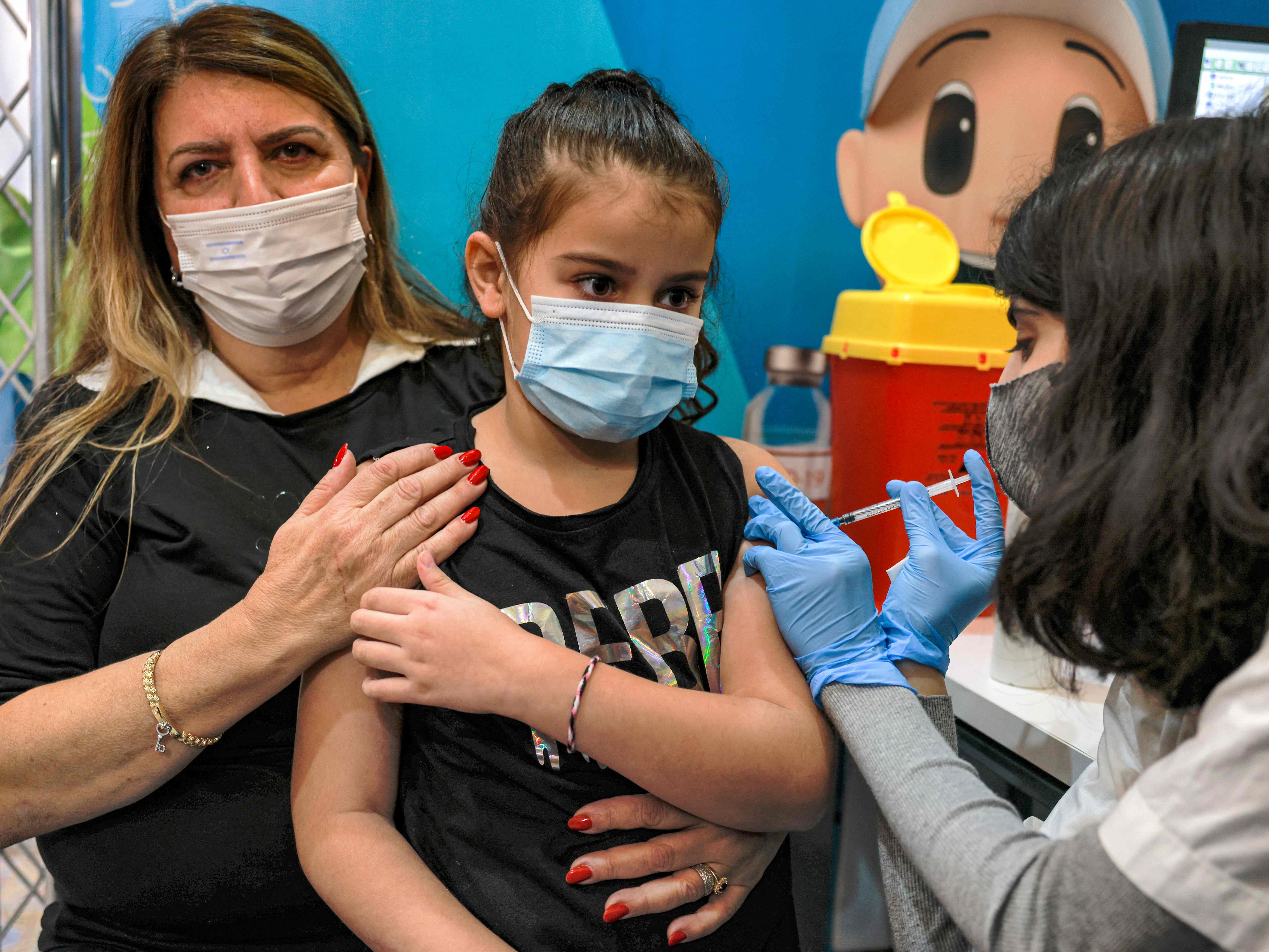 Seorang petugas kesehatan Israel memberikan dosis vaksin covid-19 Pfizer/BioNTech kepada seorang anak berusia delapan tahun.