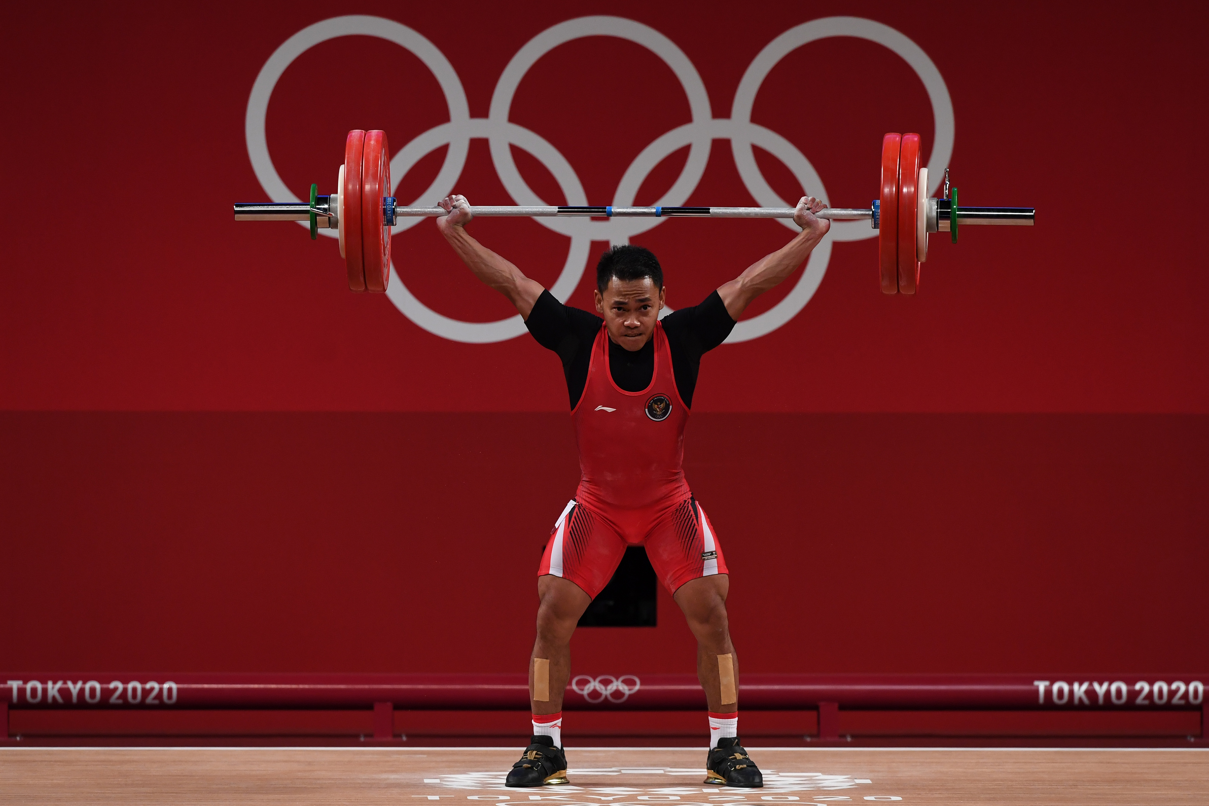 Lifter Indonesia Eko Yuli Irawan melakukan angkatan snatch dalam kelas 61 kg Putra Grup A Olimpiade Tokyo 2020.